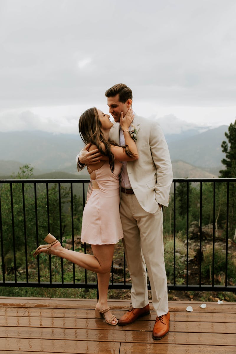 Wedding guests wearing a tan suit for men and a short pink dress