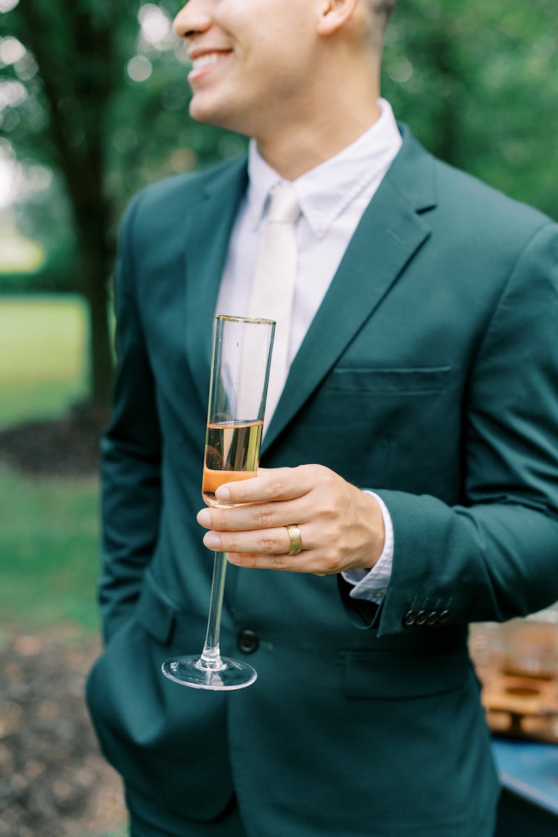 Stylish men's cocktail outfit in green suit and minimalist accessories.