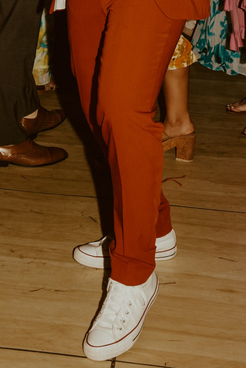 Burnt rust orange suit dress pants dressed down with white sneakers