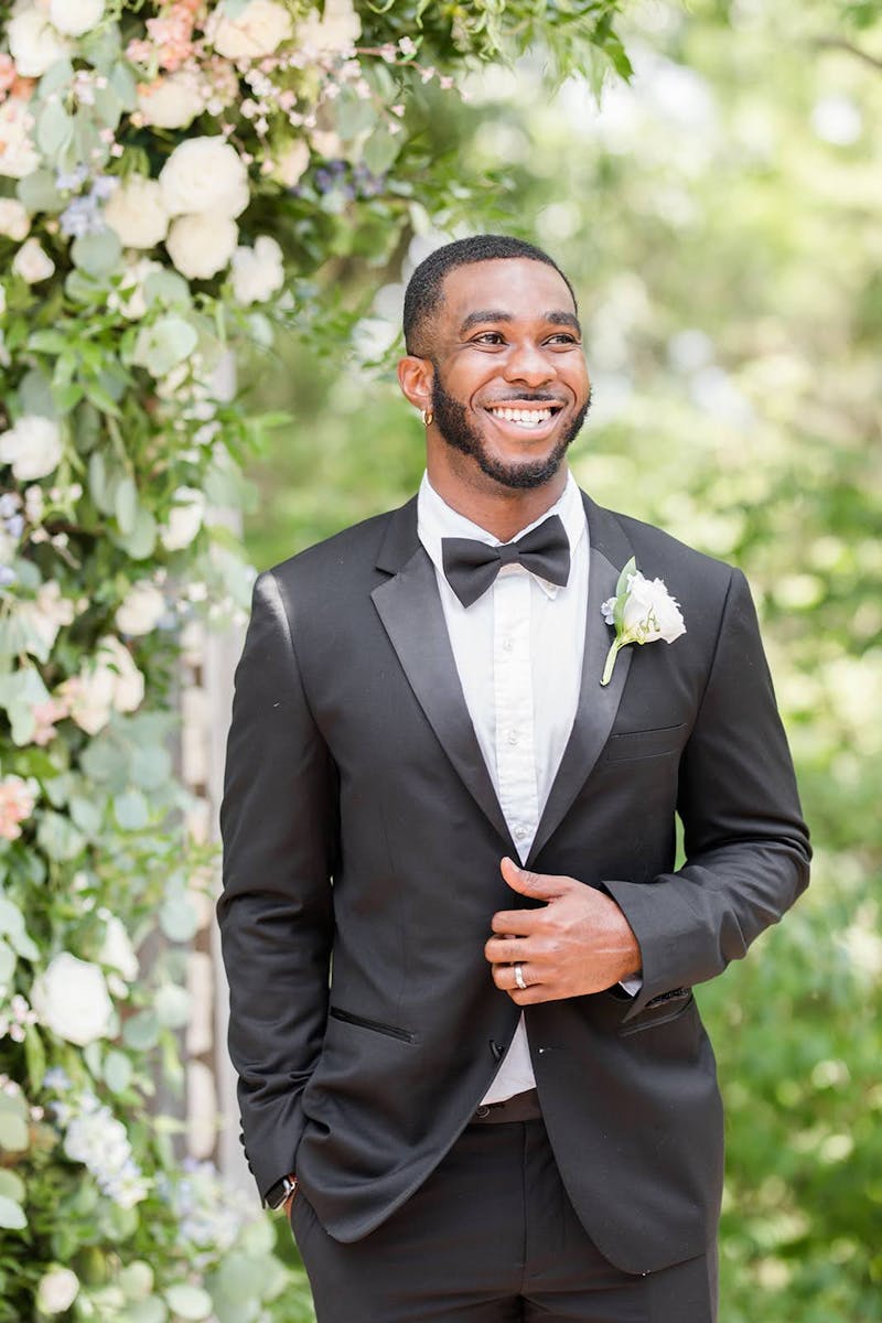 Groom wearing black tuxedo and white boutonniere for his wedding
