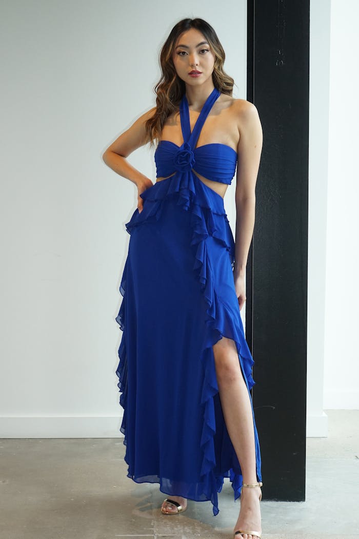 Woman wearing cute black-tie dress in blue with halter neck, ruffles, and cutouts