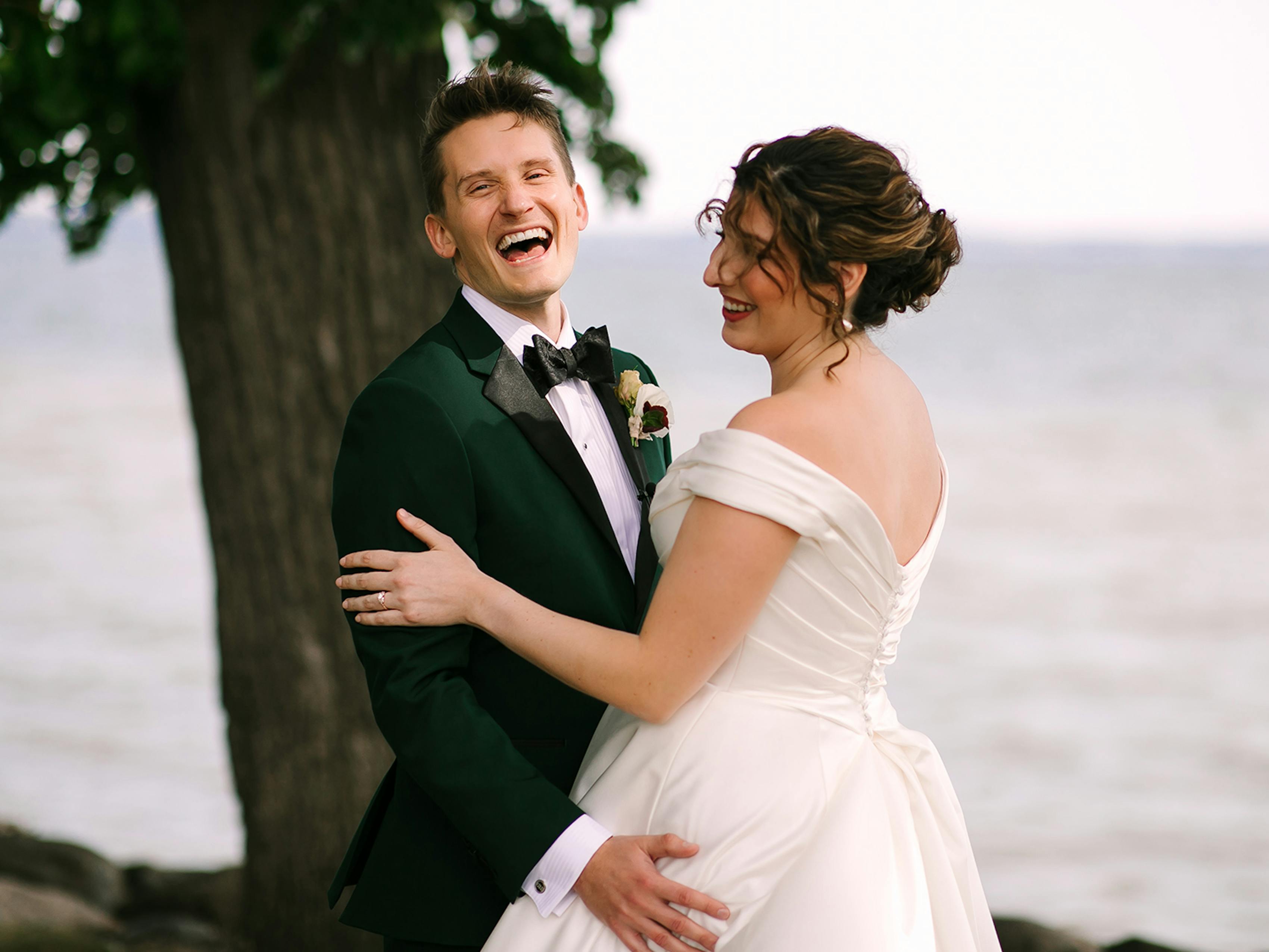Bride and groom's first look in their elegant wedding attire by a lake in Wisconsin.