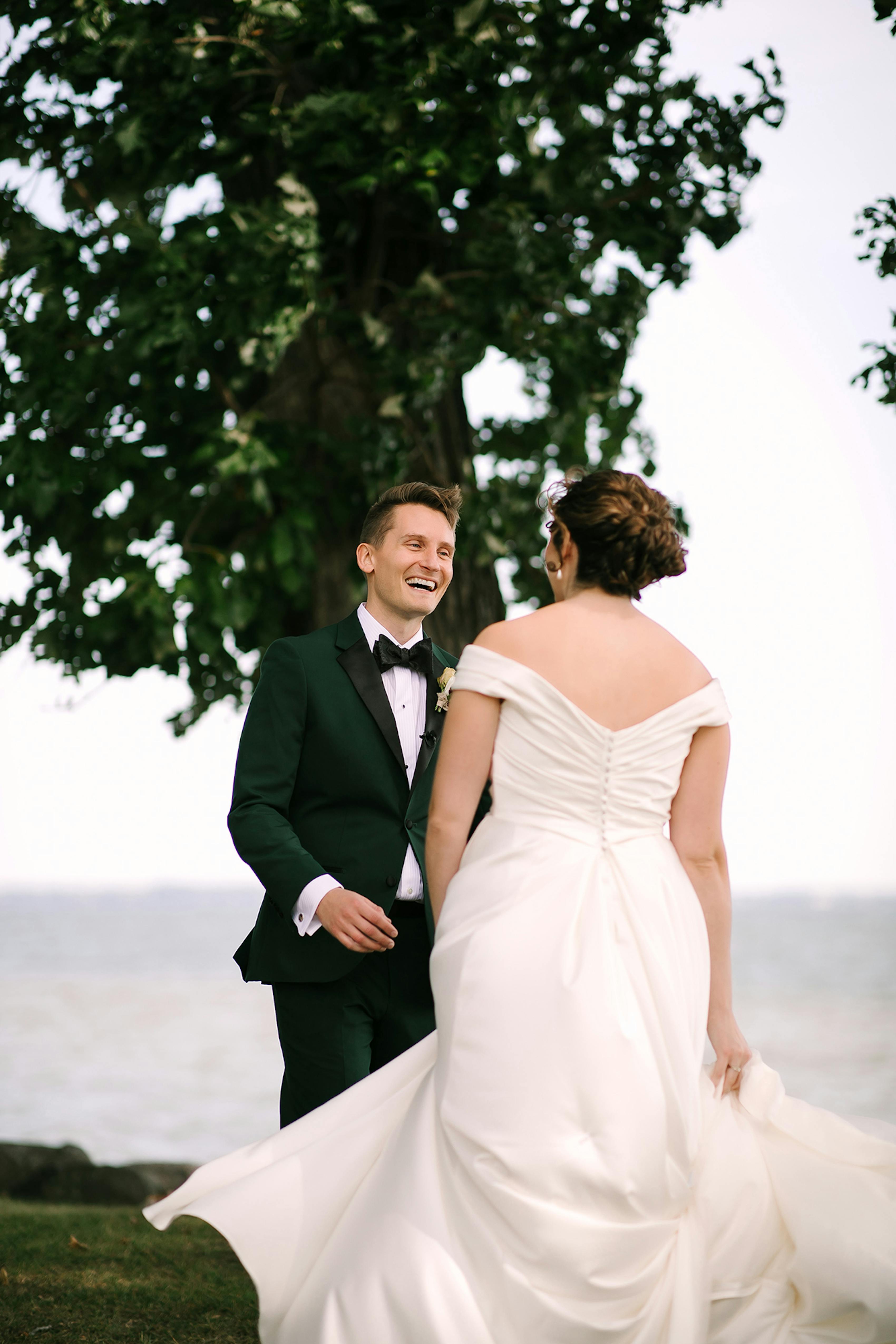 Bride and groom share a first look outdoors next to the lake.