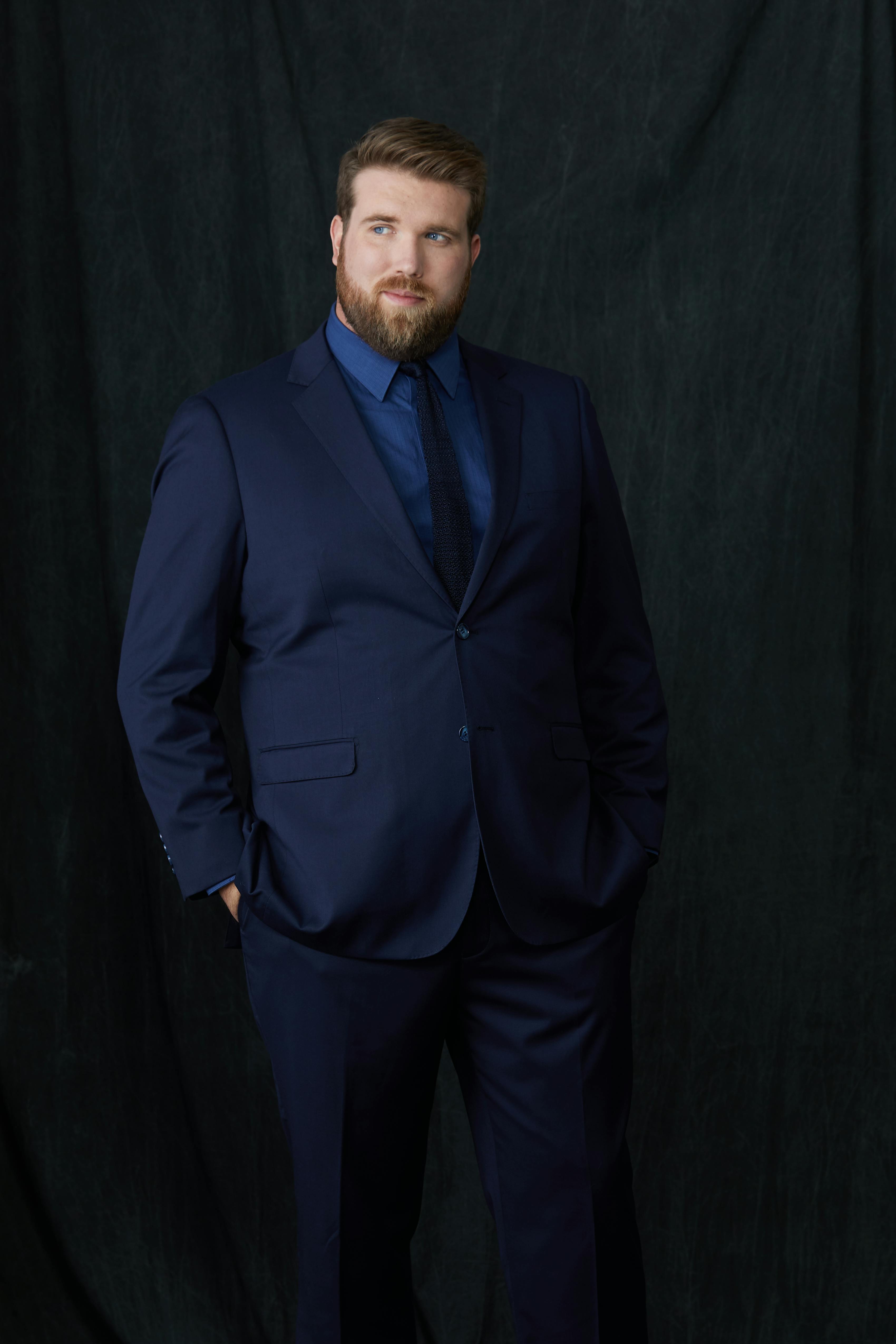 Men's navy blue suit for a funeral with a dark blue shirt and tie.