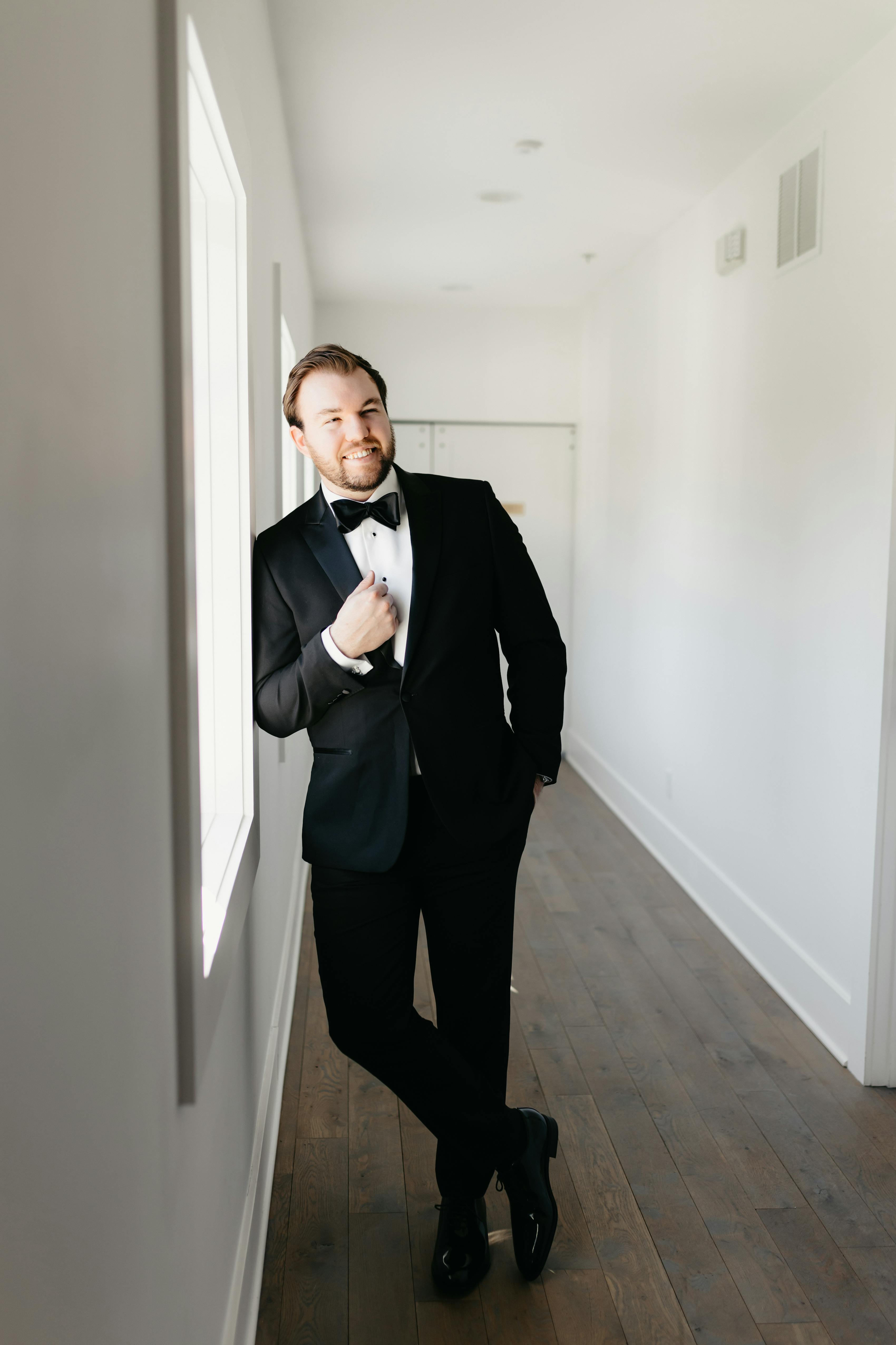 Classic men's tuxedo outfit with a shiny satin black bow tie