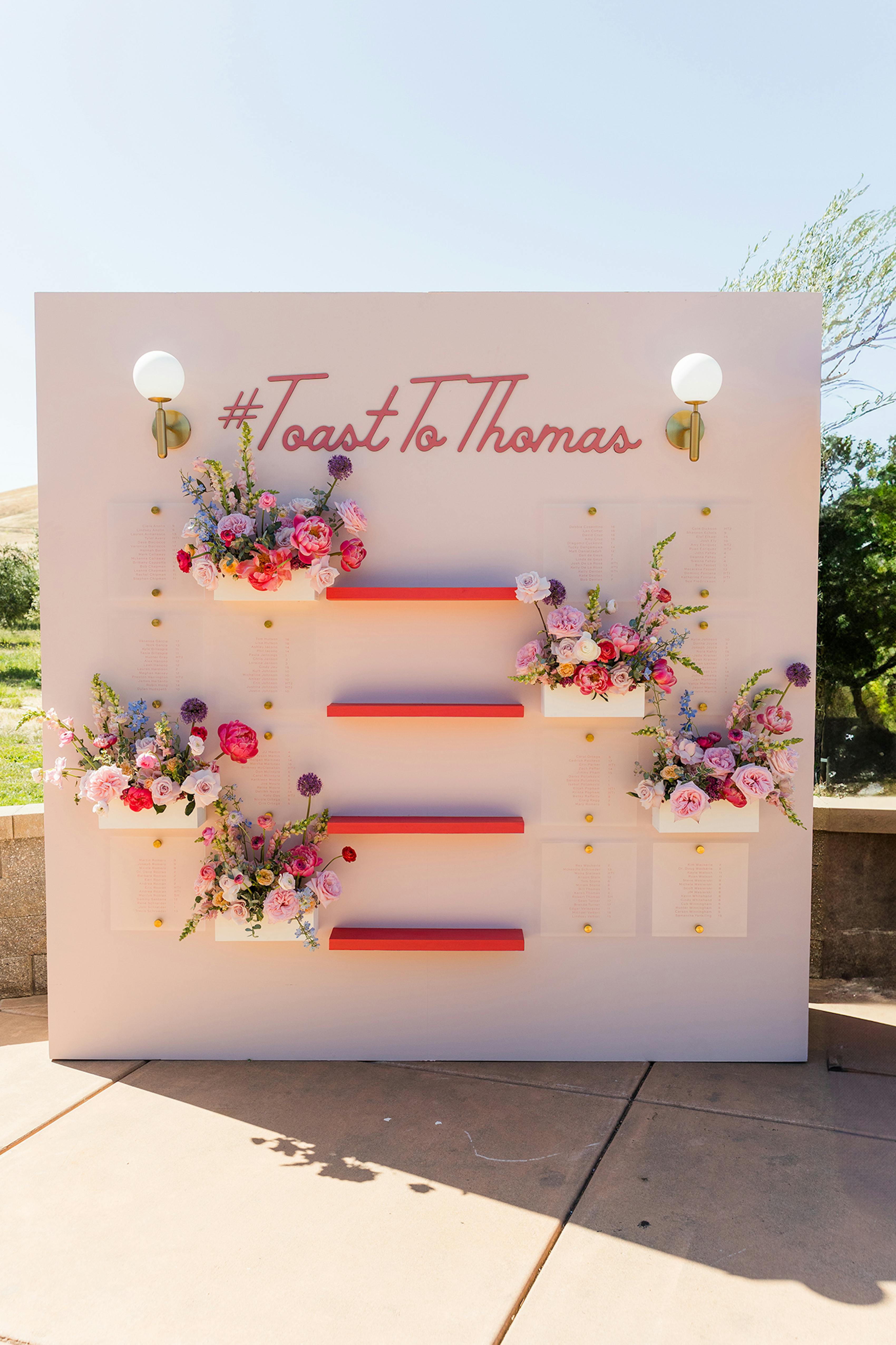 Gorgeous free standing wedding guest seating chart with champagne and bouquets.