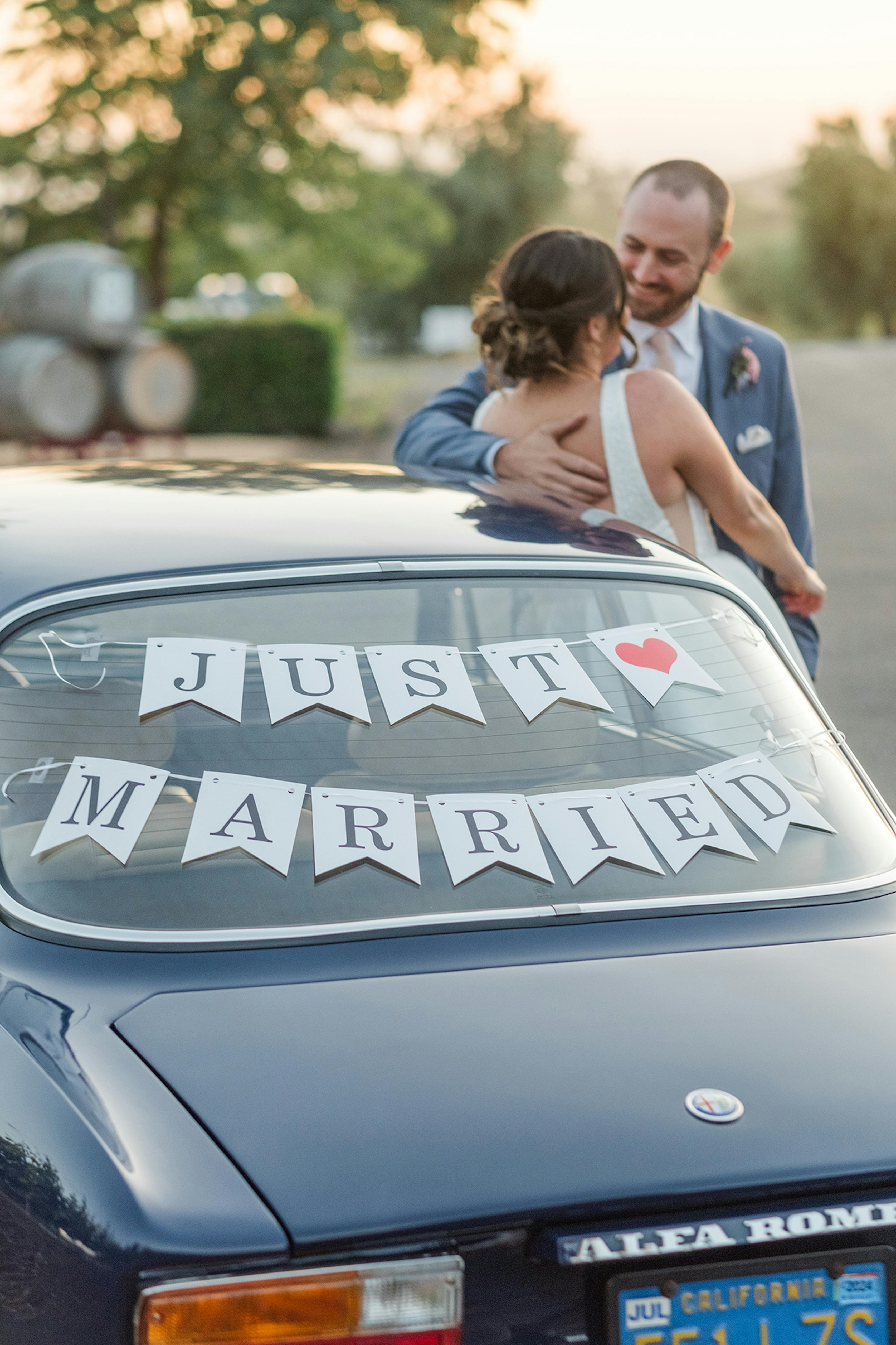 Wedding getaway car with just married sign in the back windshield.