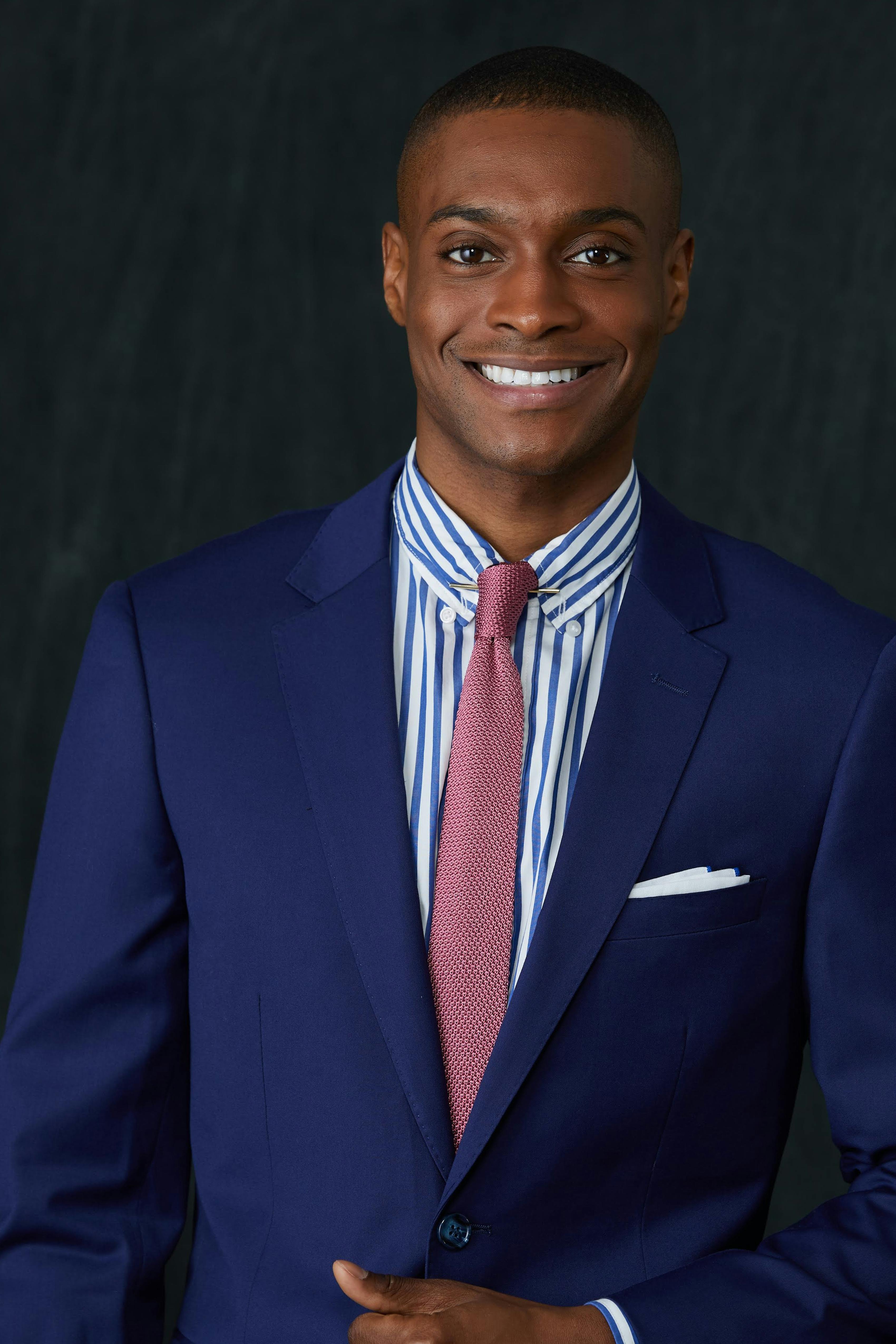 Kelvin knot for a pink knit necktie with stripped button-up and suit for a professional men's outfit