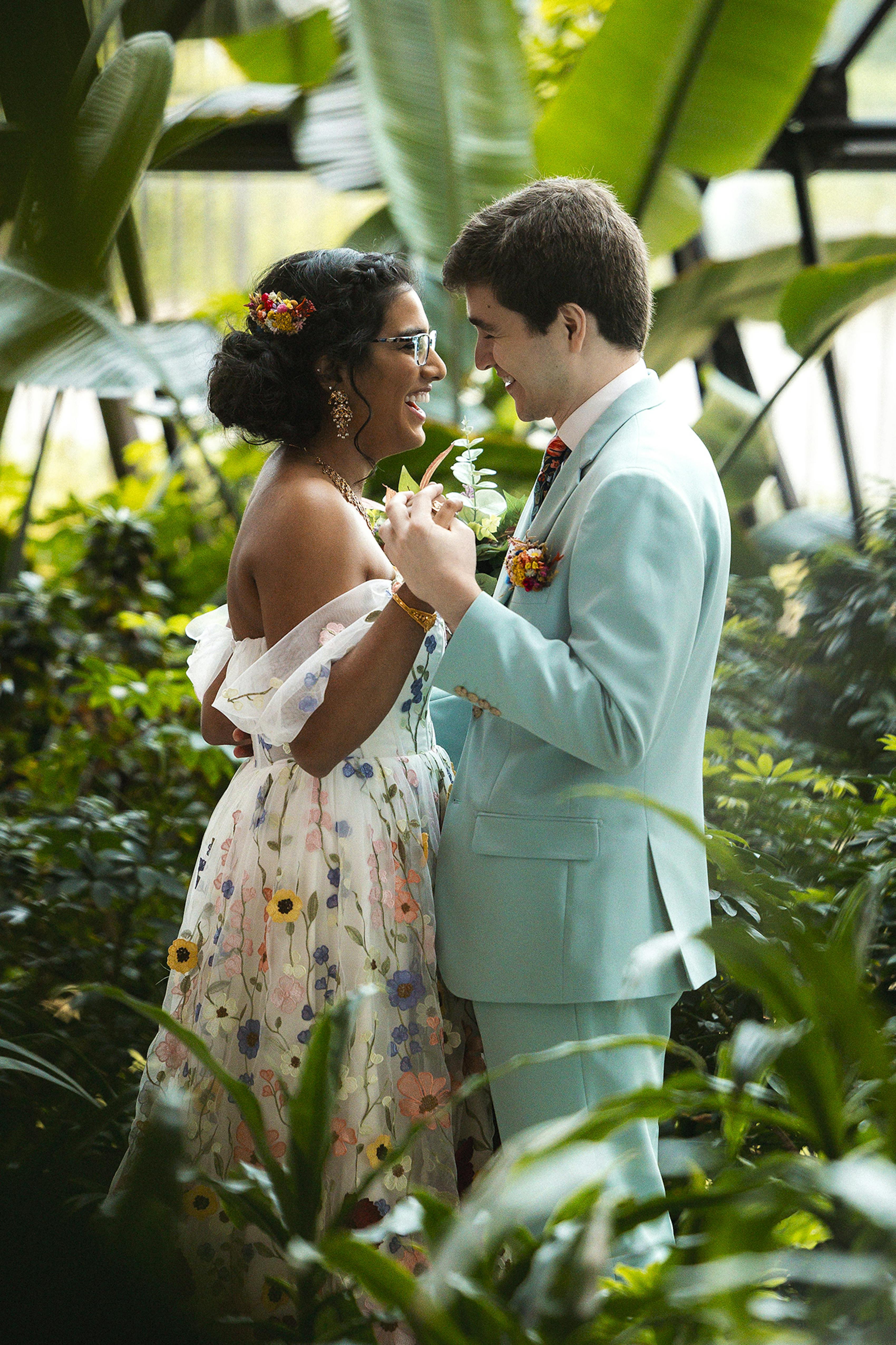 Bride and groom share an intimate first look, wearing a floral weddin gown & seaglass groom's suit