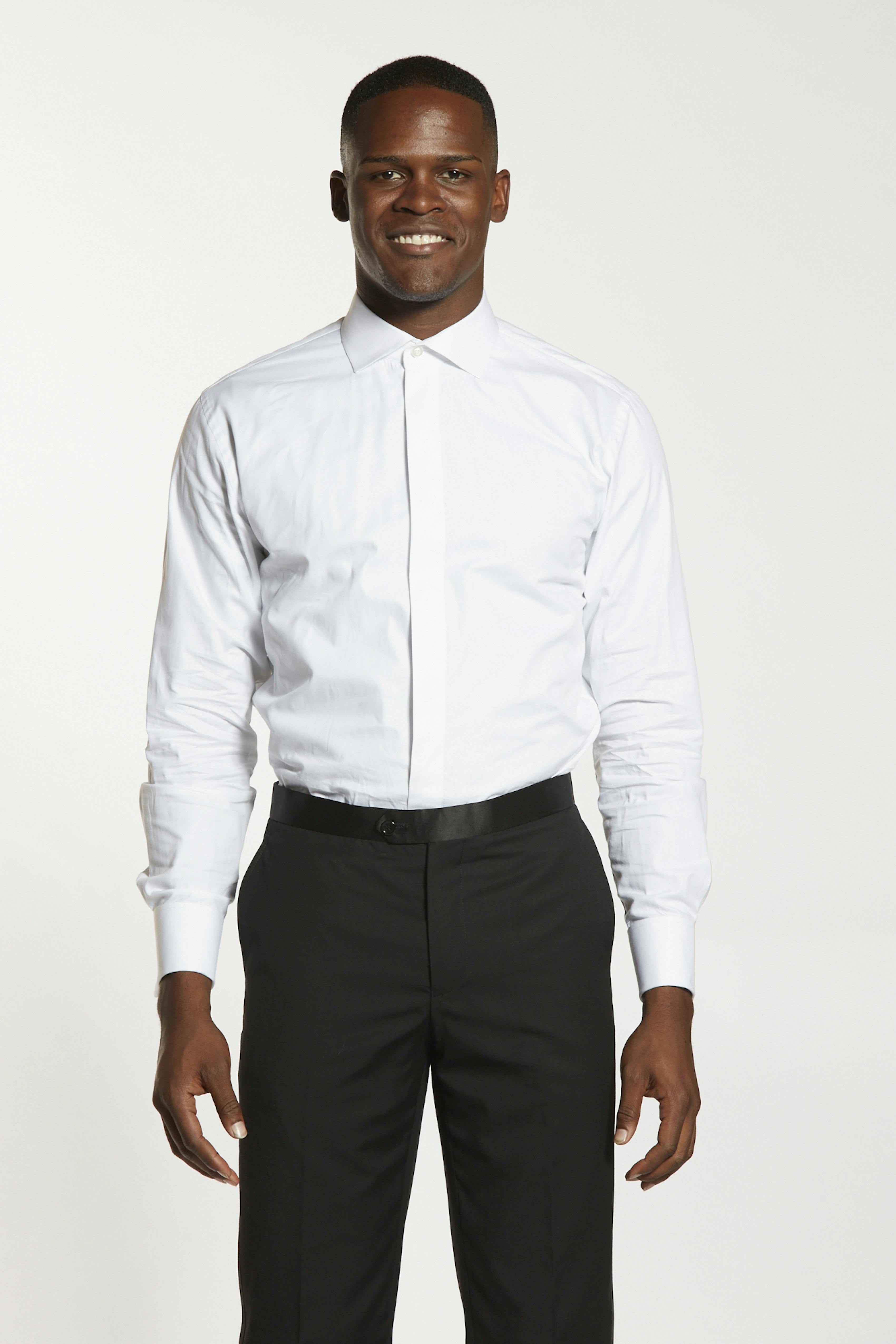 Man wearing French cuff dress shirt with crewneck undershirt for his tuxedo outfit.