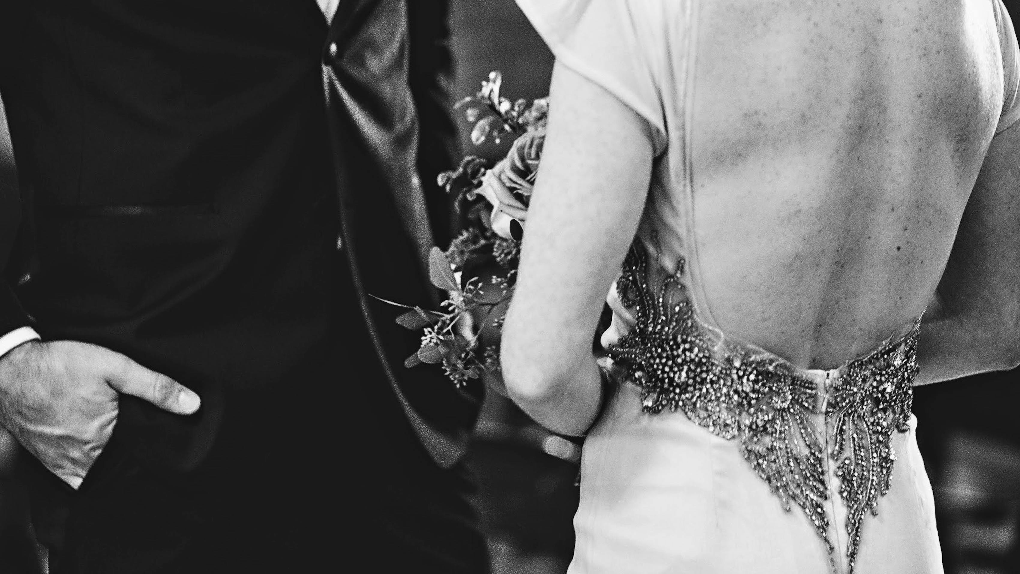 Man and woman dressed in white tie attire with a beaded gown and black formal tuxedo
