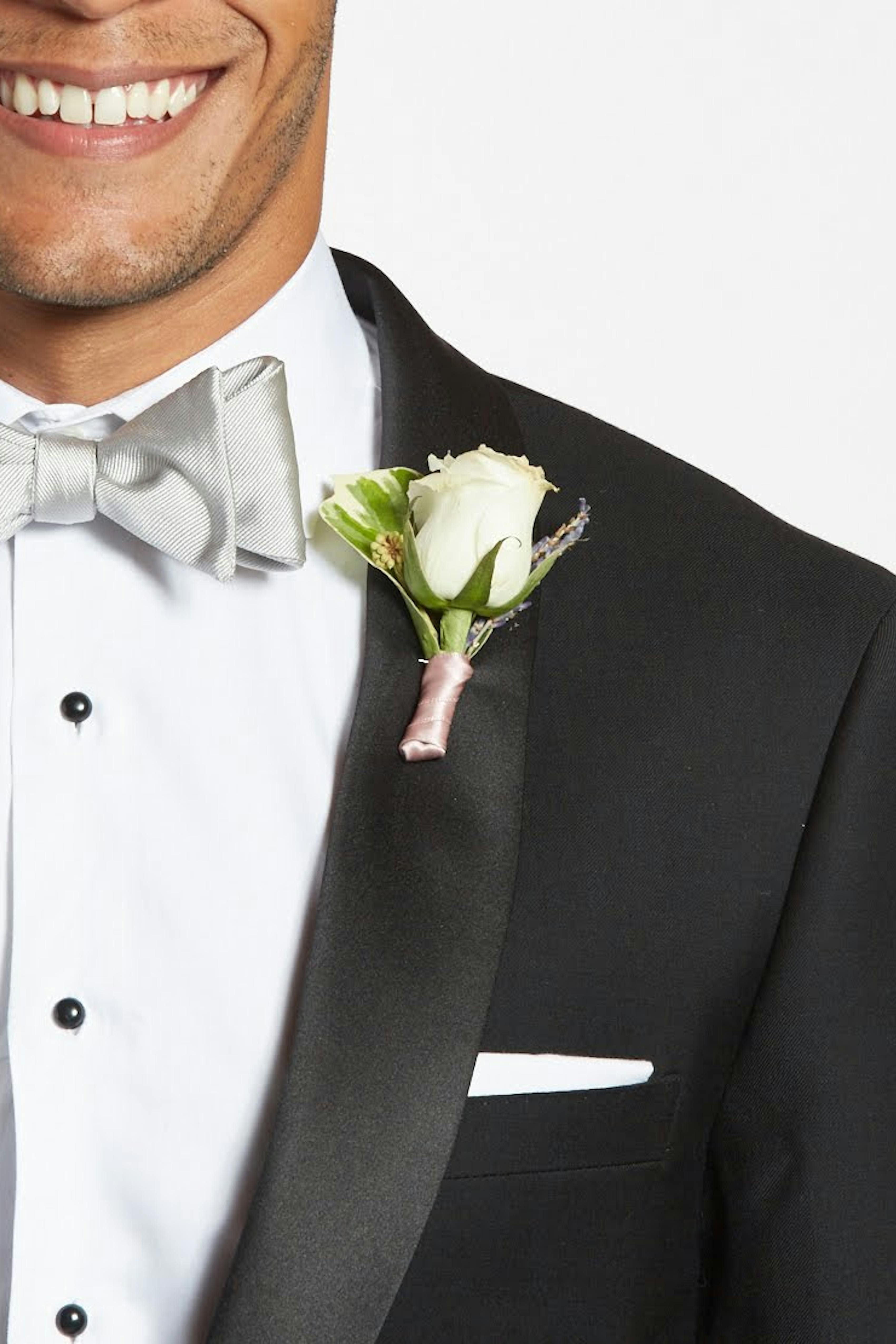 Man dressed for white tie event in a black shawl lapel tuxedo and ivory bow tie.