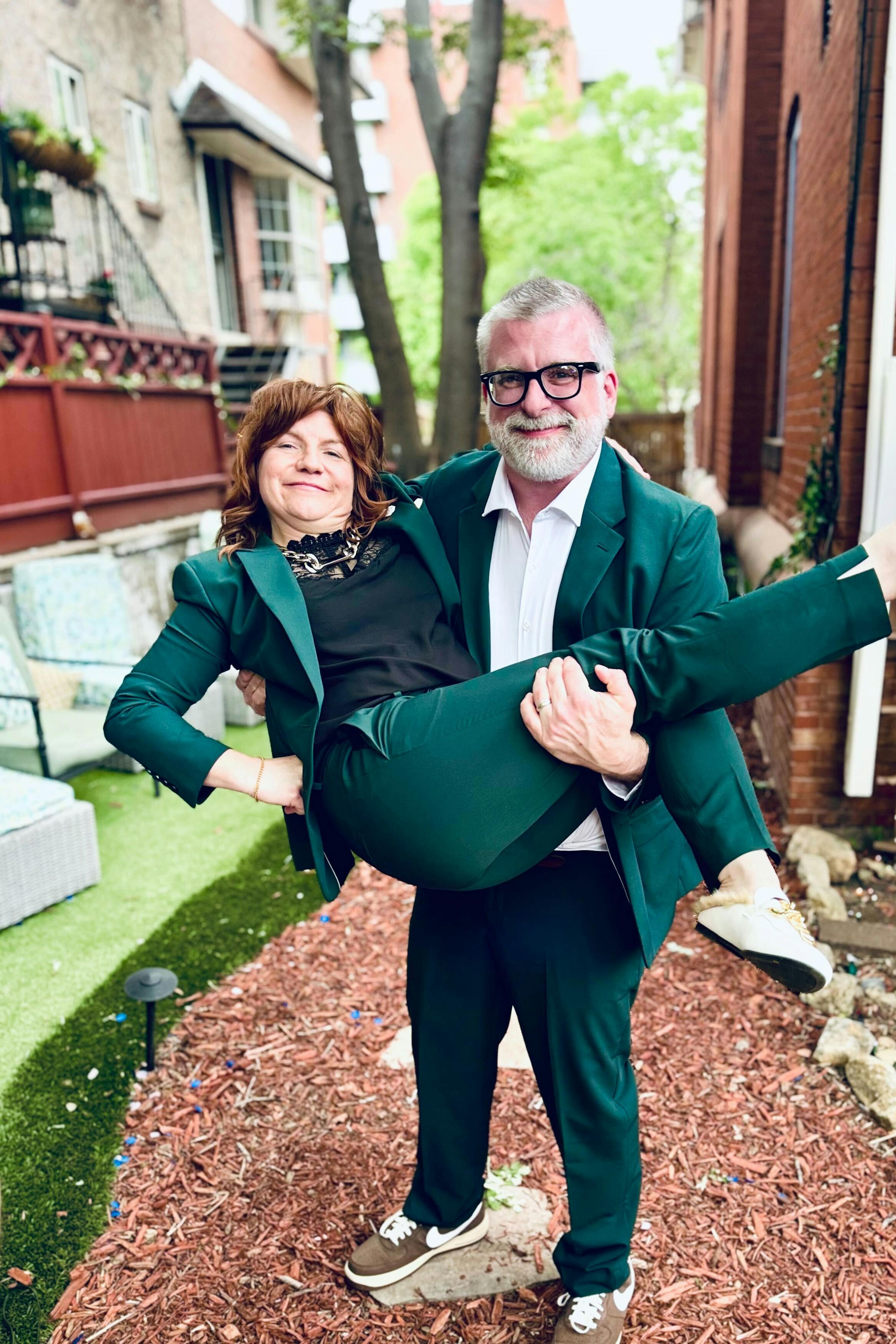 Father of the bride and mother of the bride in matching hunter green wedding suits