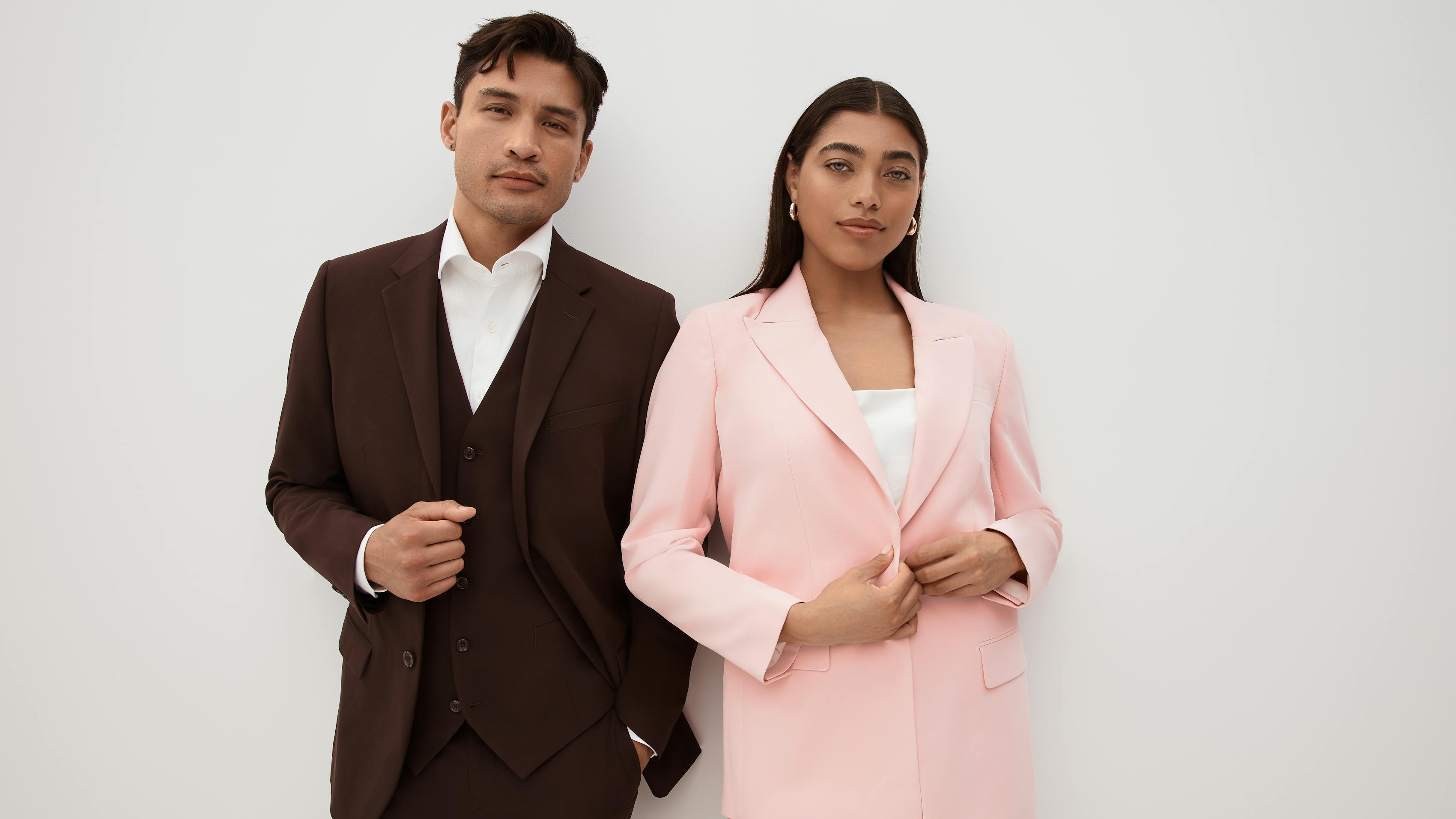 Wedding date couple wearing fall suit colors in a men's brown suit and women's blush pink suit skirt.