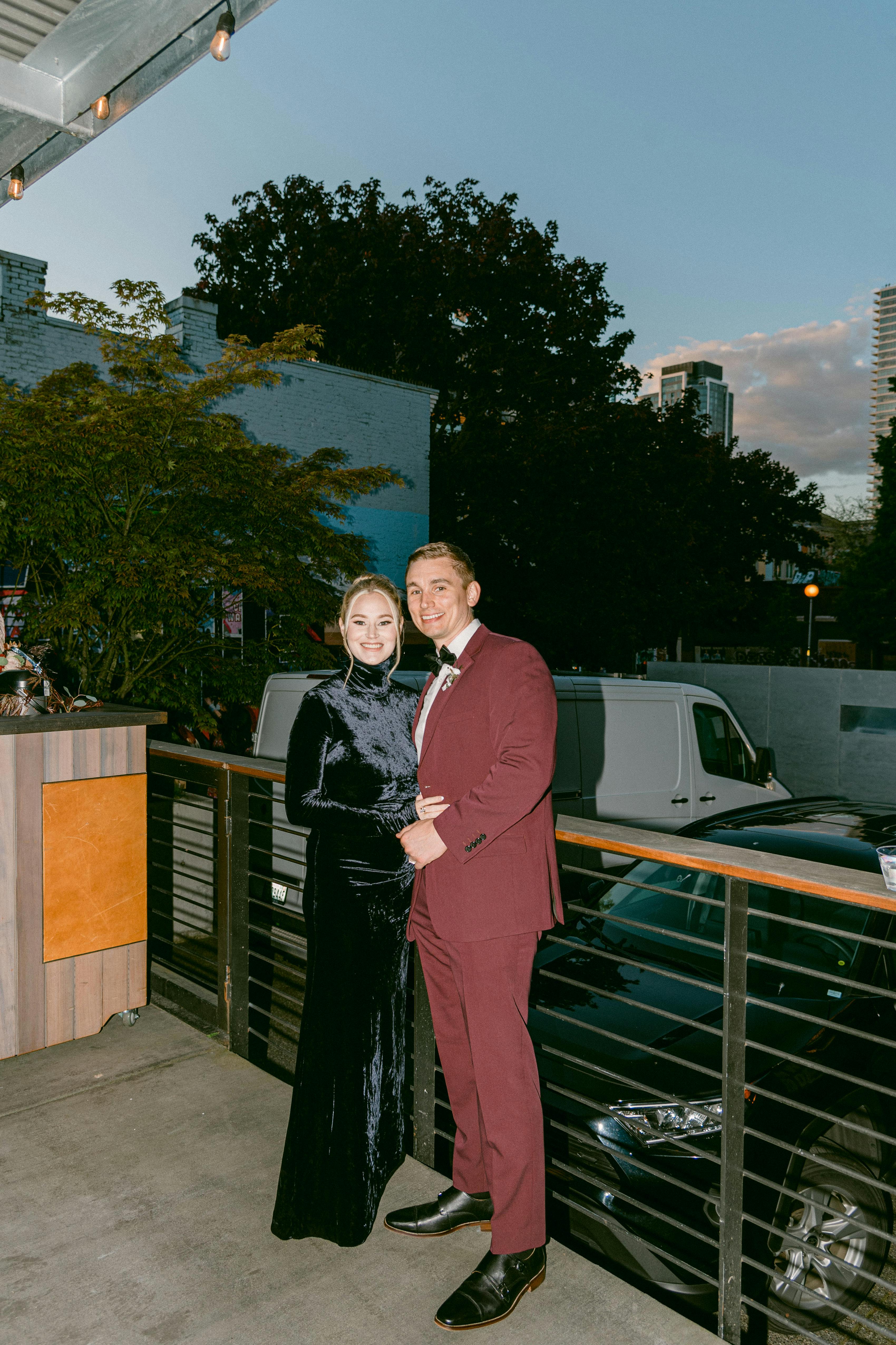 Fall wedding guest style in men's red suit and women's velvet dress.