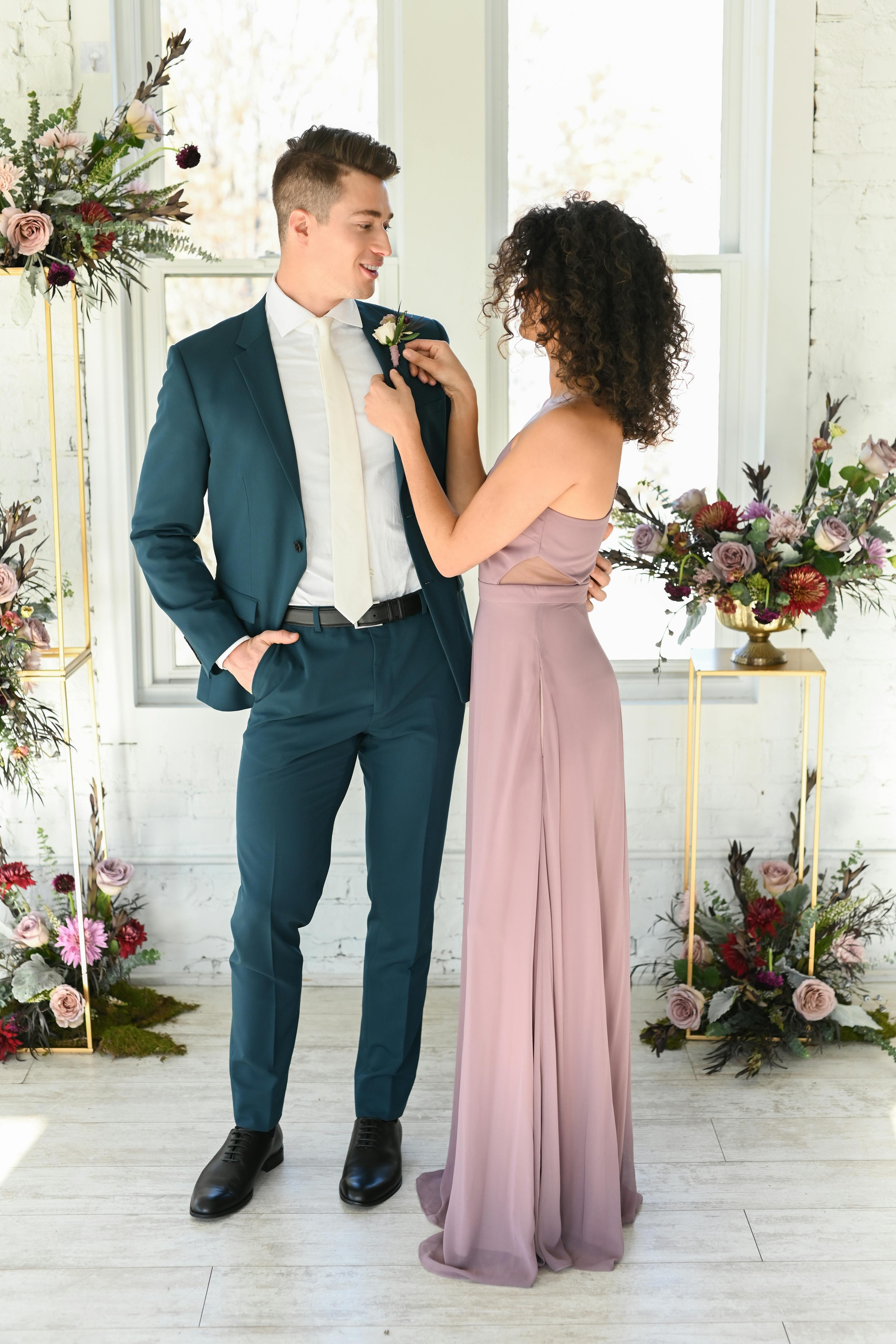 Semi-formal wedding guest attire with men's teal suit for fall and light purple dress.