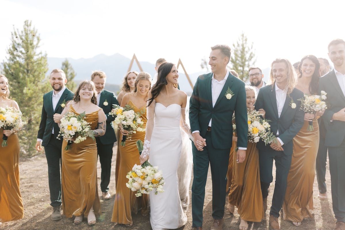 Earth tone wedding group with marigold yellow bridesmaid dresses and forest green groomsman suits