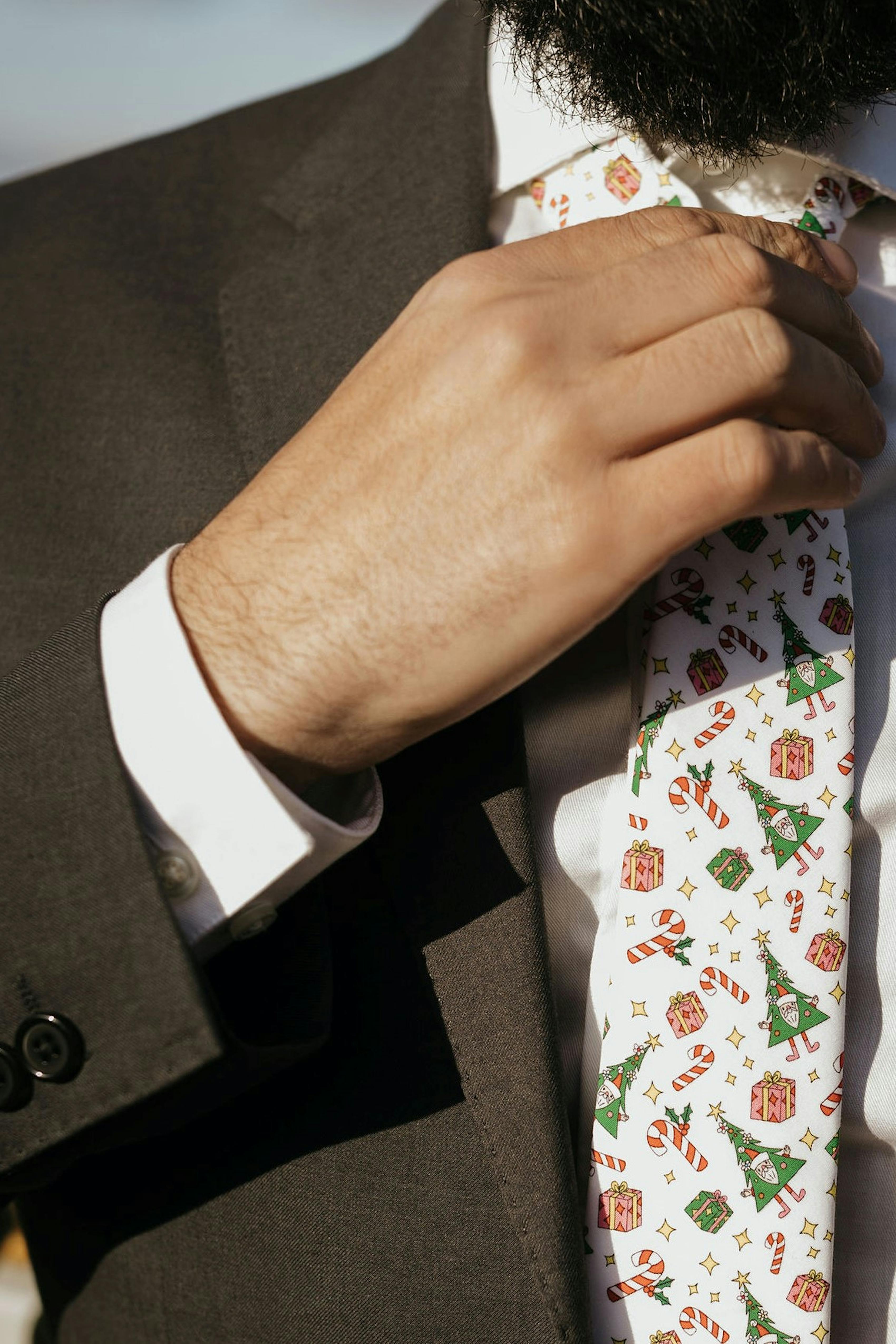 A classic black suit, styled with a festive tie with a Christmas tree pattern