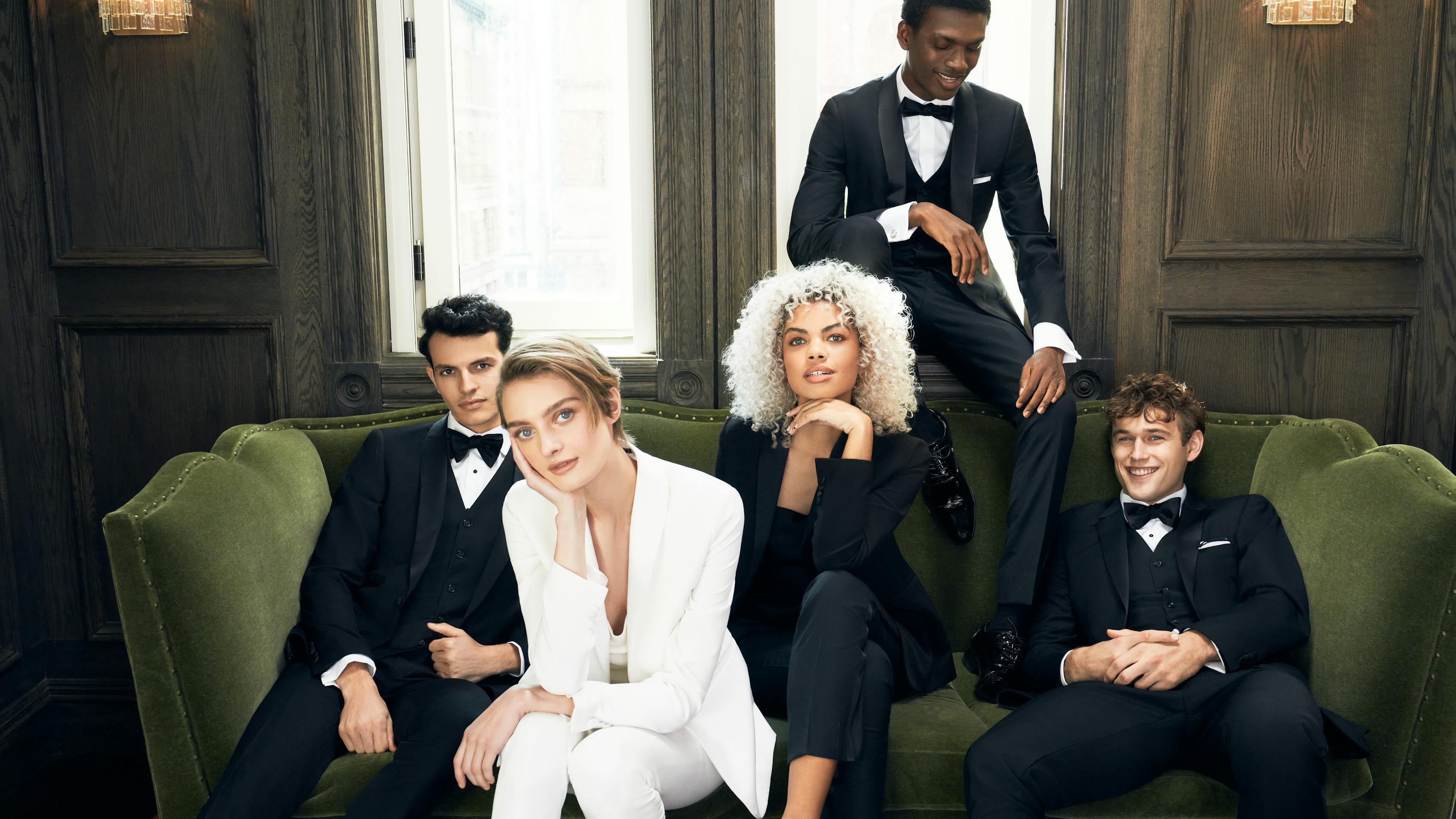Stylish group of men and women wearing black tie holiday party attire