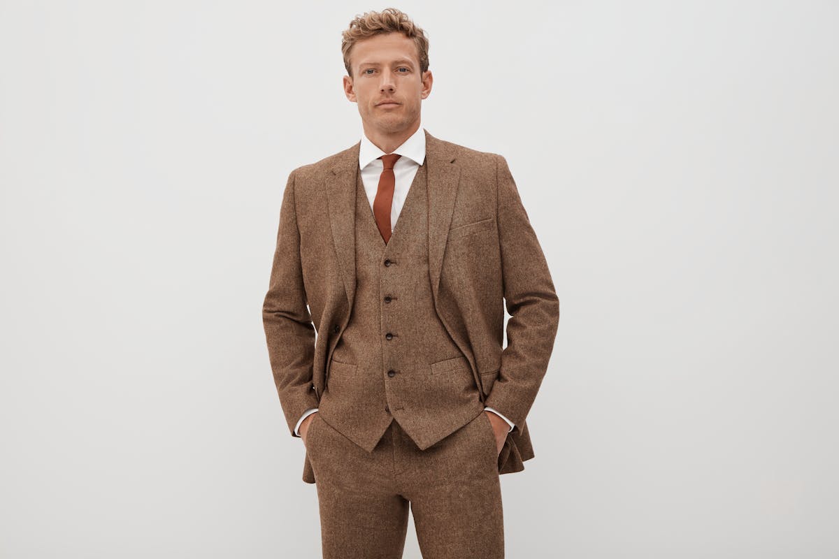 Men's three piece tweed suit styled with a rust necktie 