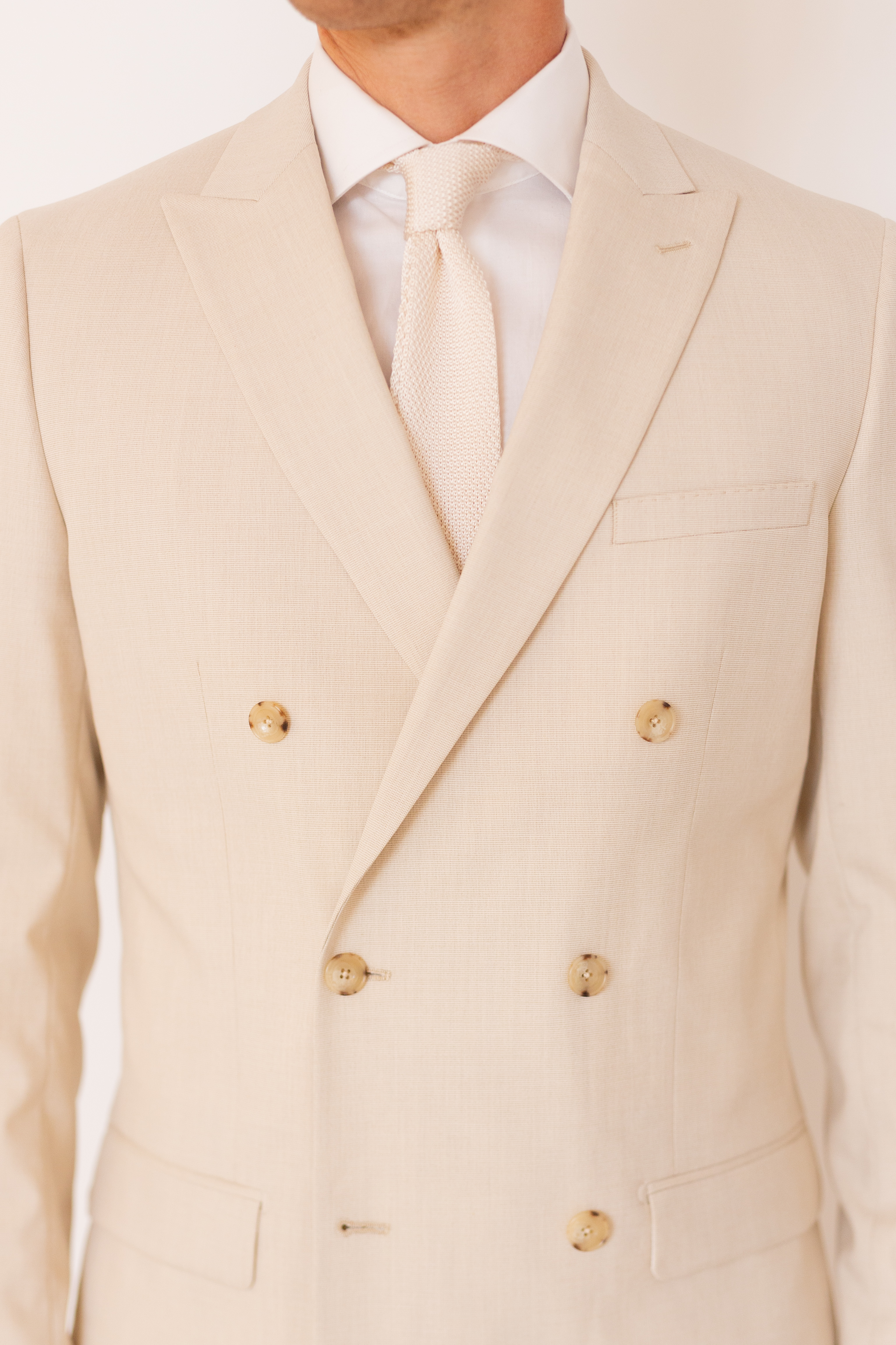 Detail of men's double breasted jacket 6-button front in tan suit color