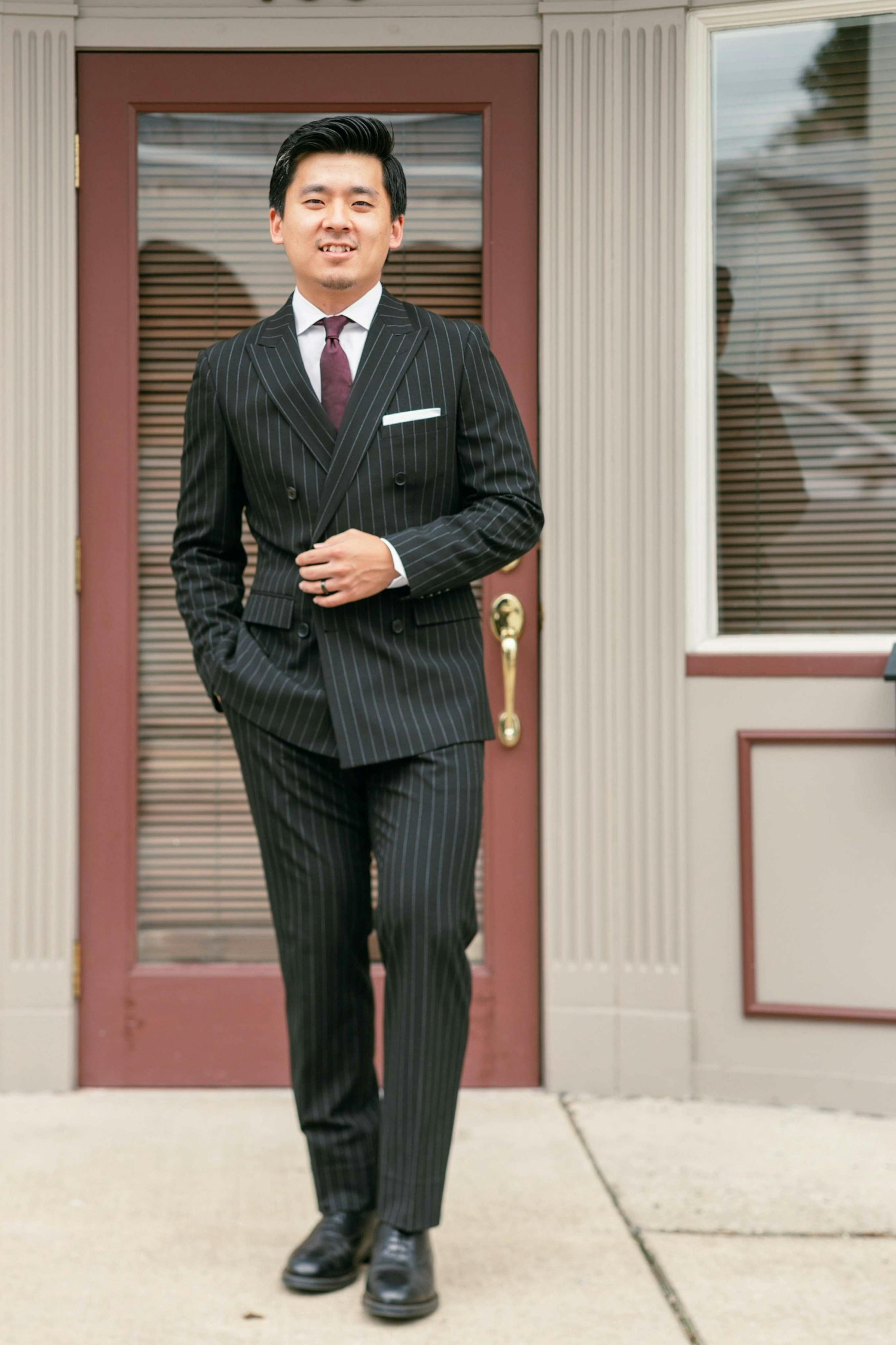 Man wearing black pinstripe double-breasted suit for fashionable formalwear and street style