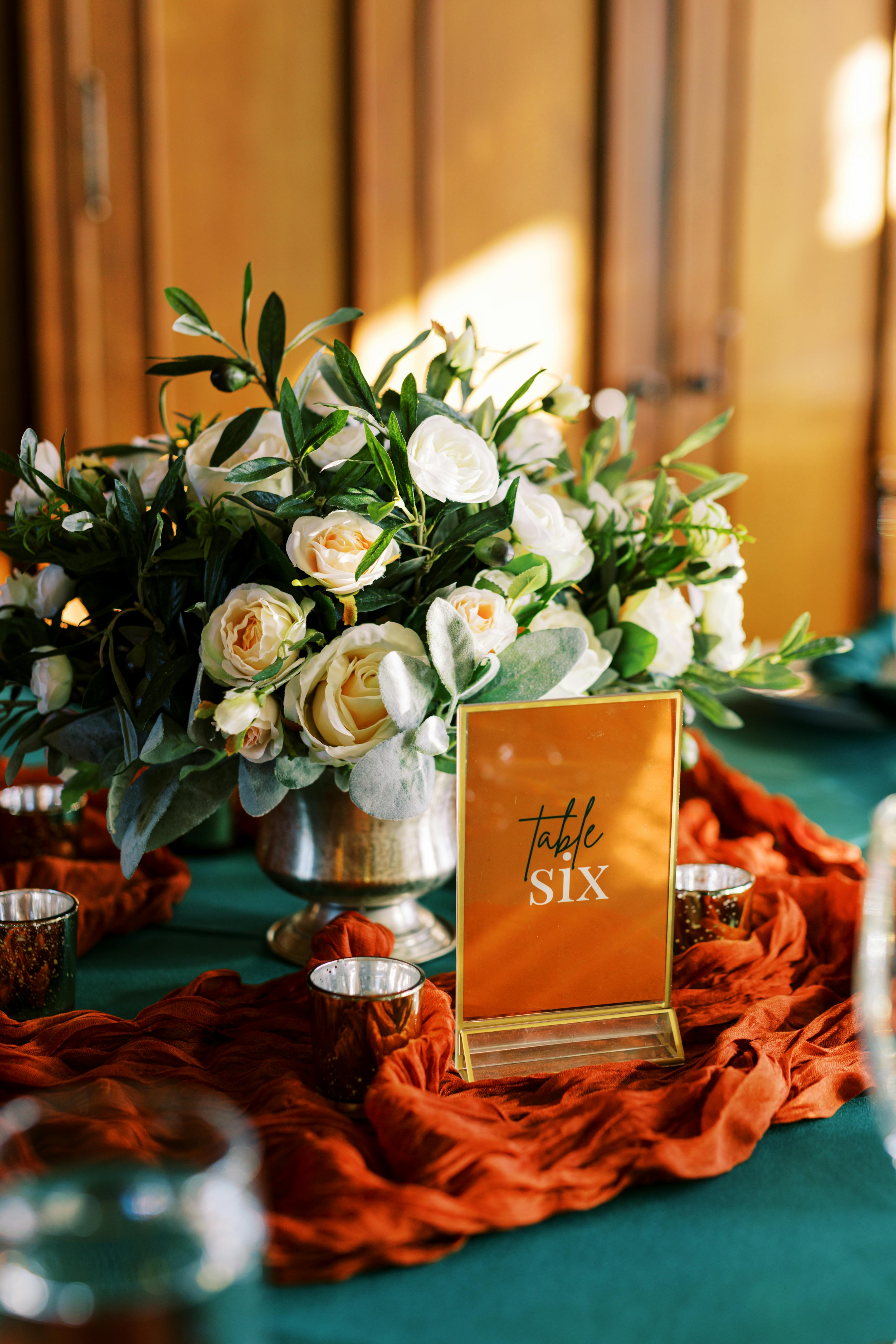 Emerald green and burnt orange wedding tablescape details and florals