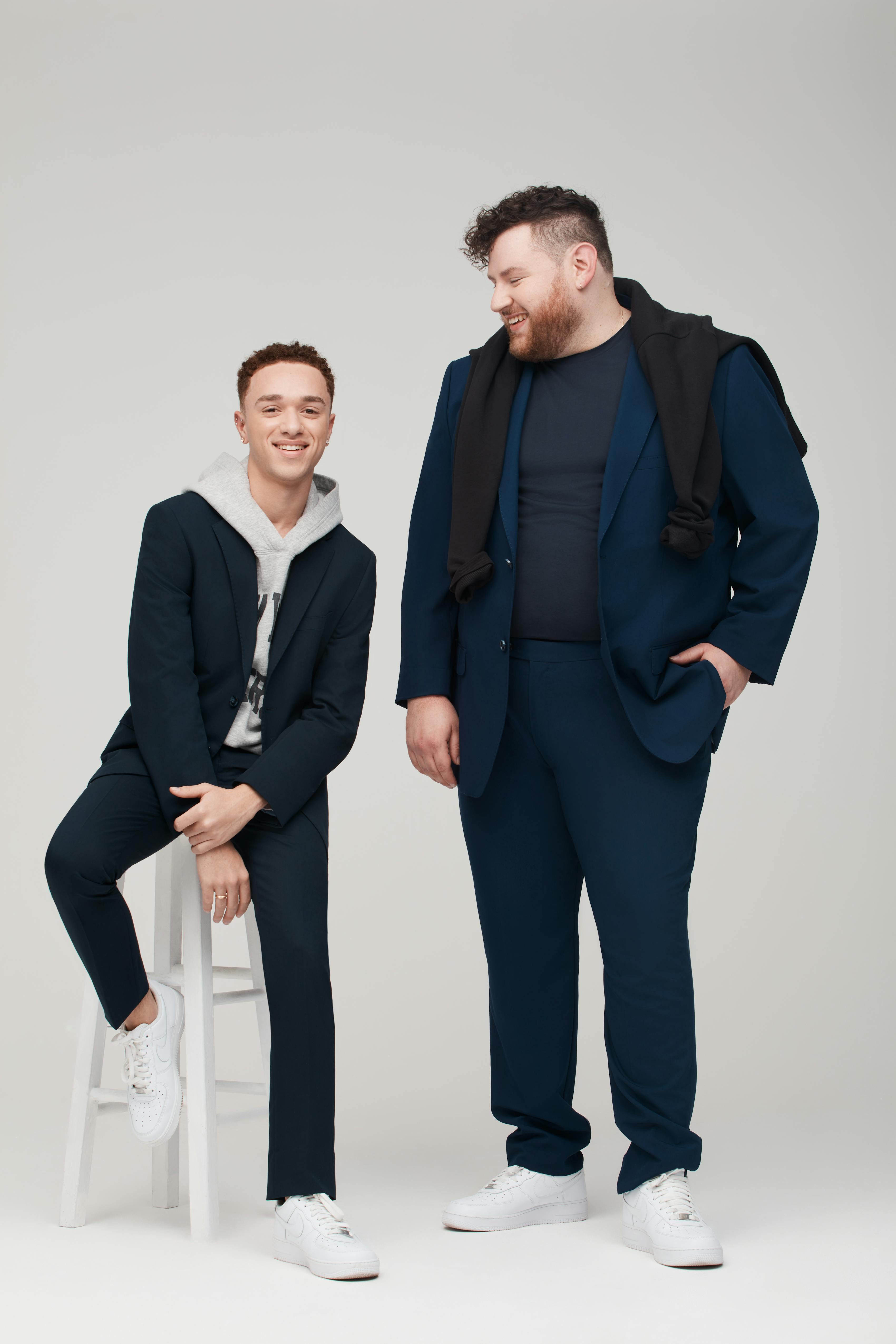 Teen guy wearing casual navy blue suit and plus sized man wearing royal blue suit.