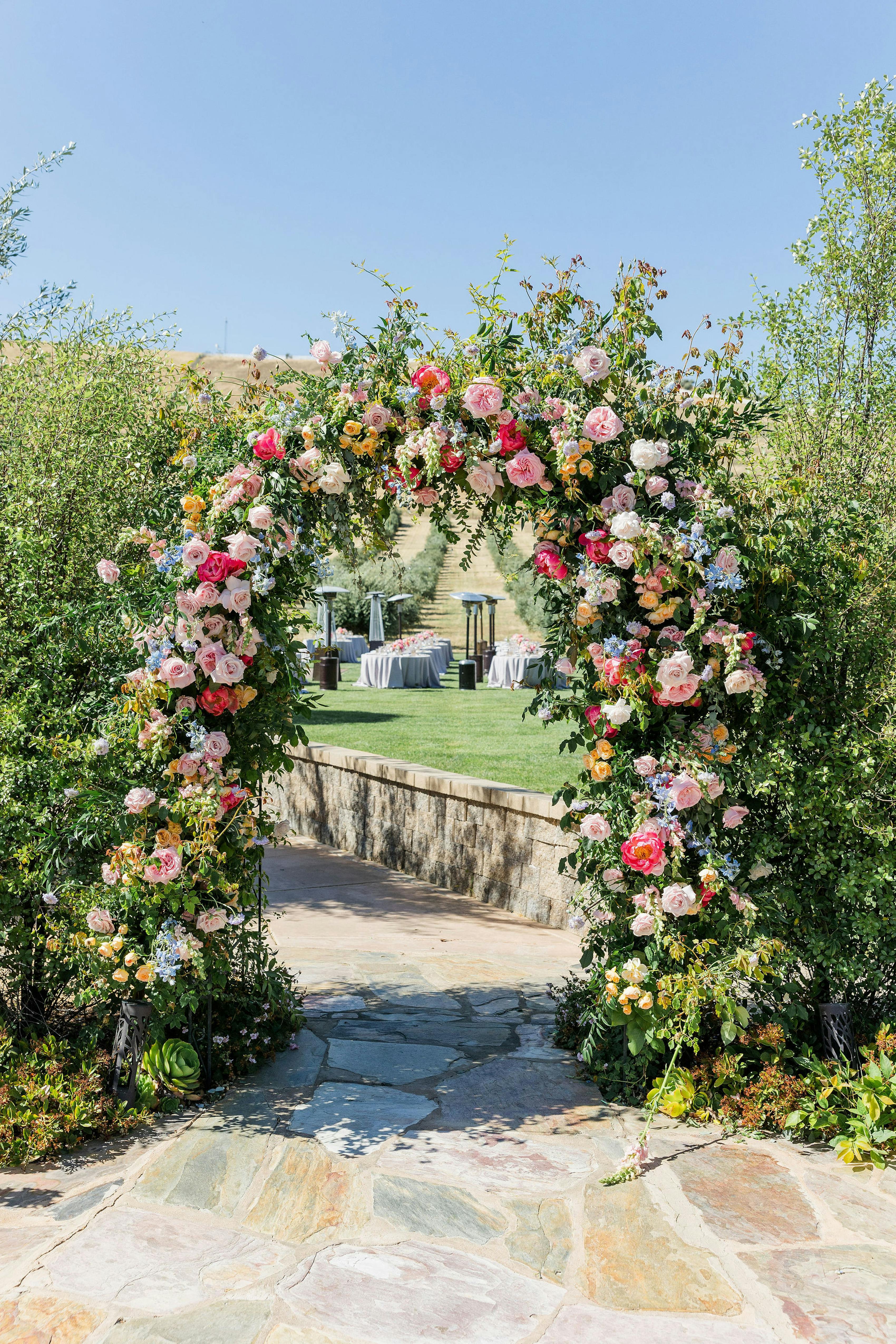 Grand green and pink floral arch for wedding ceremony backdrop.