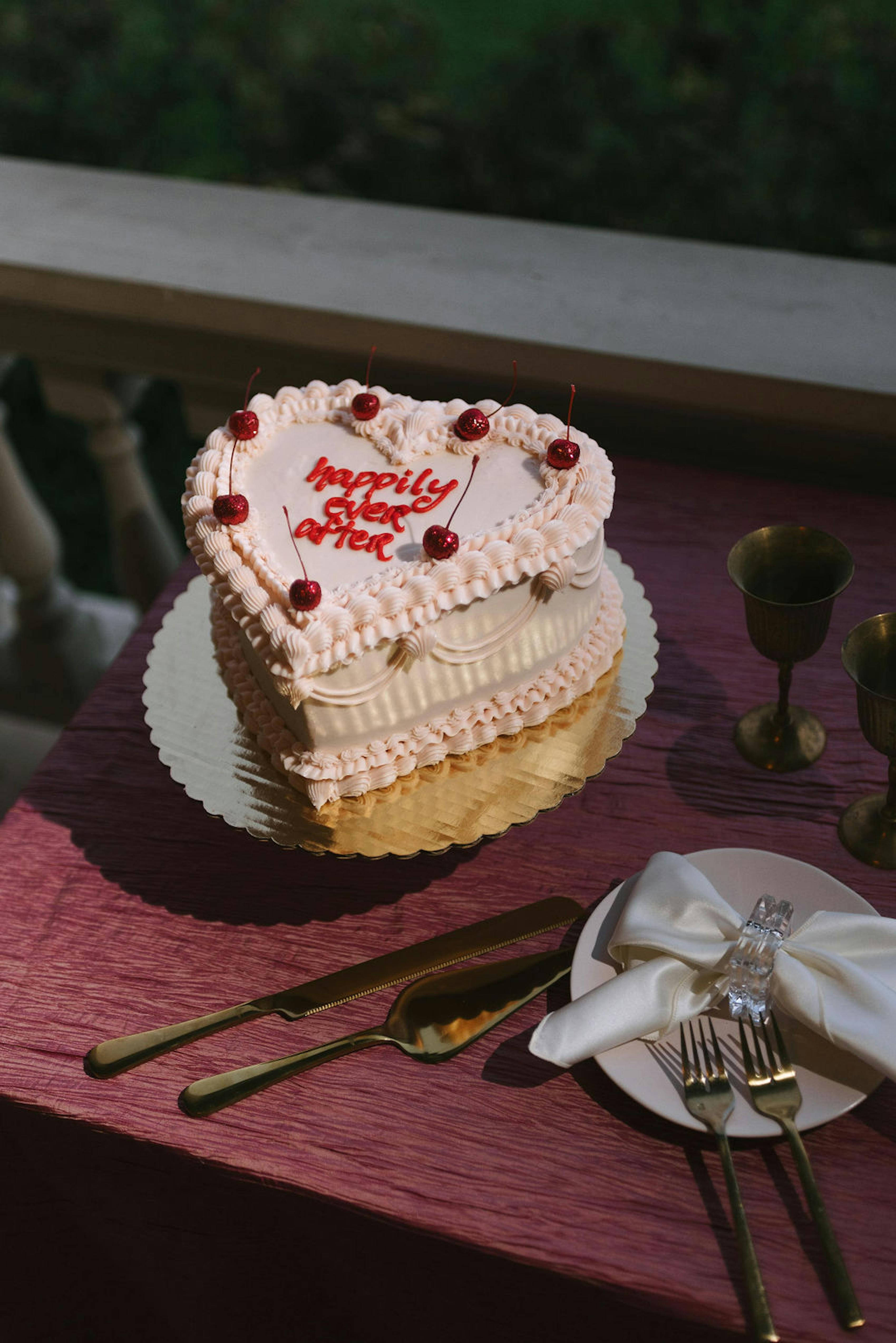 Petite heart-shaped wedding cake reads happily ever after with cherry aesthetic