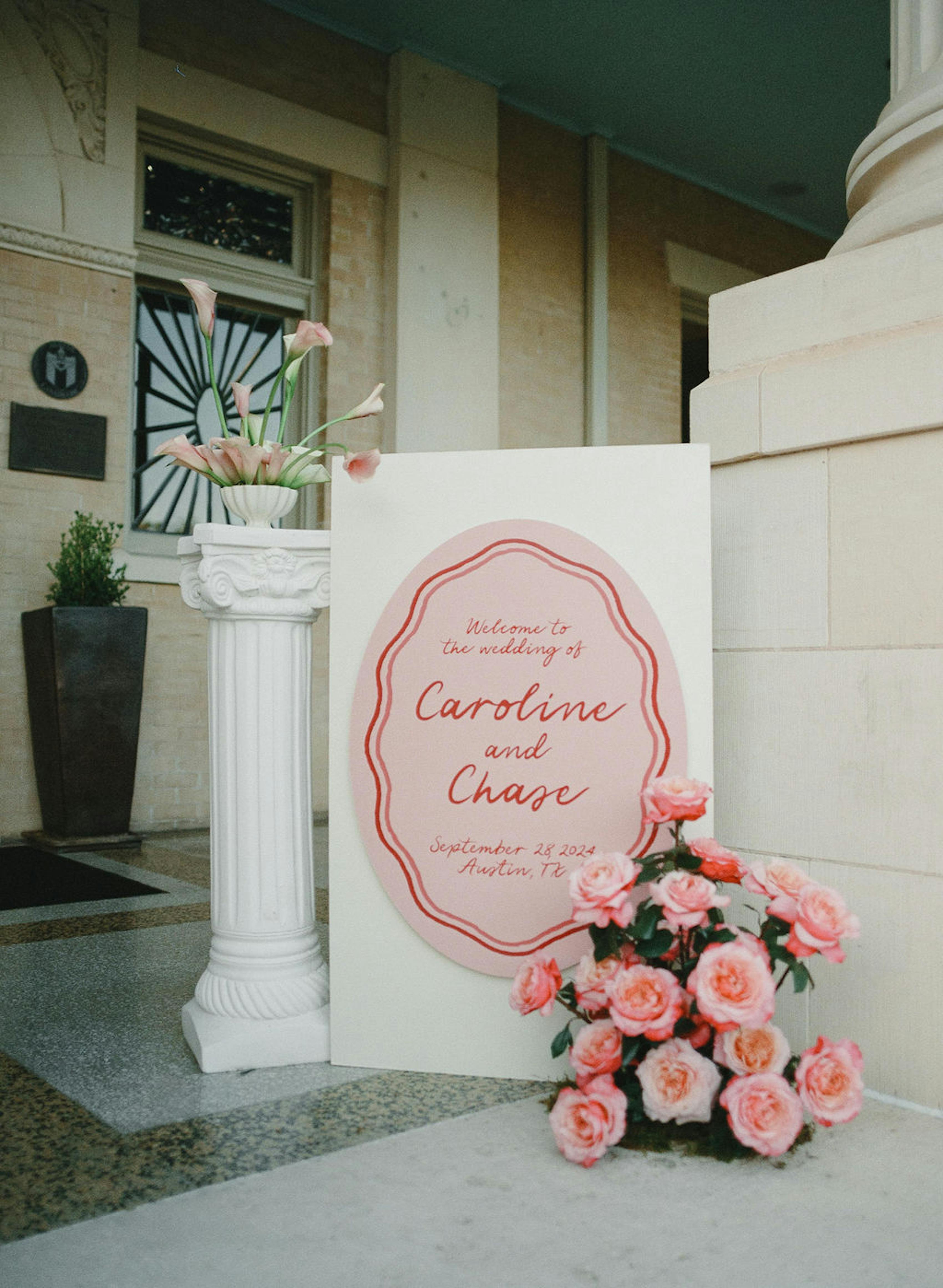 Custom pink wedding signage with bright pink flowers