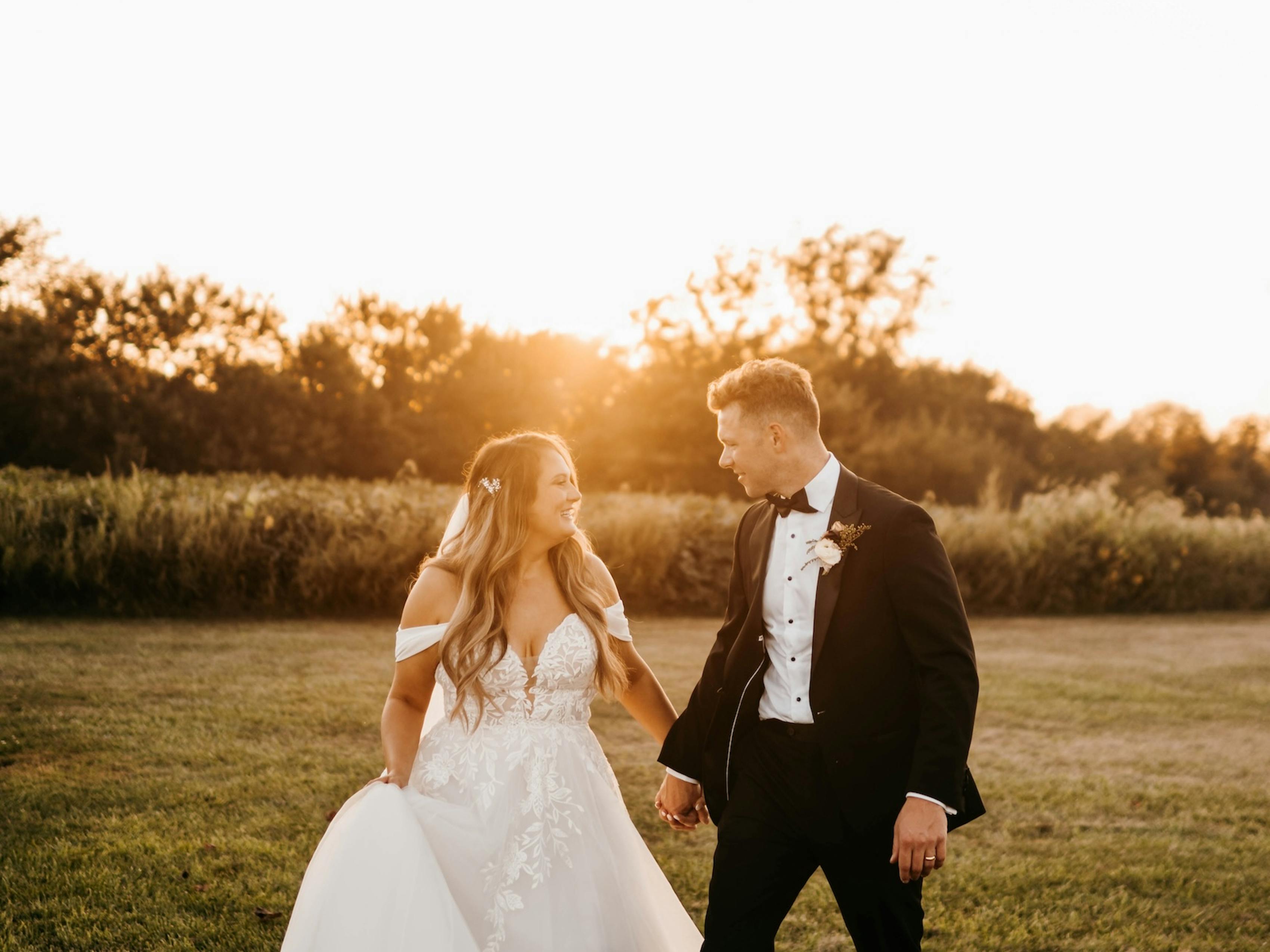 bride and groom pose together in their black tie attire after their sunset wedding ceremony