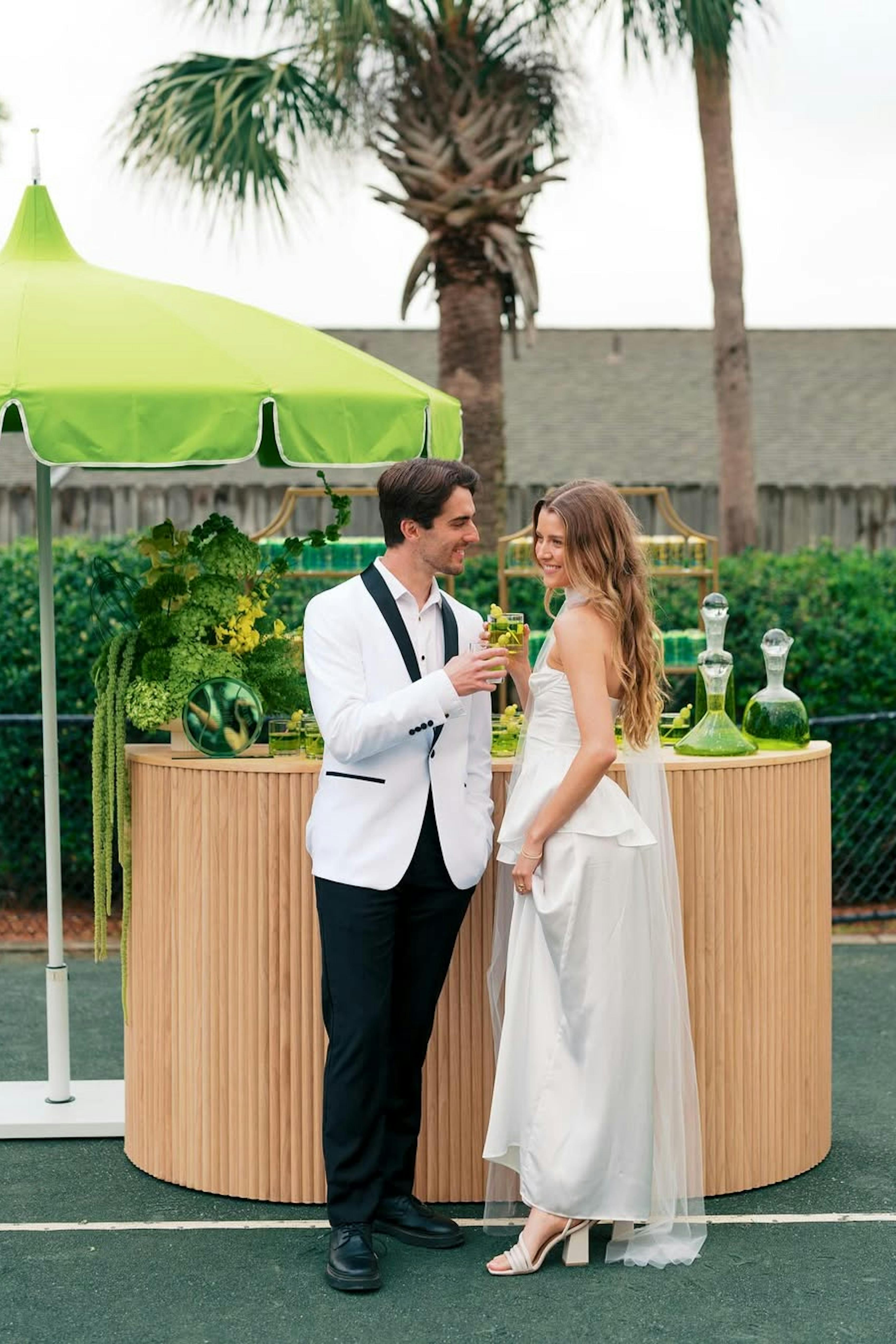 Tennis themed wedding attire with white and black groom tuxedo and satin wedding dress