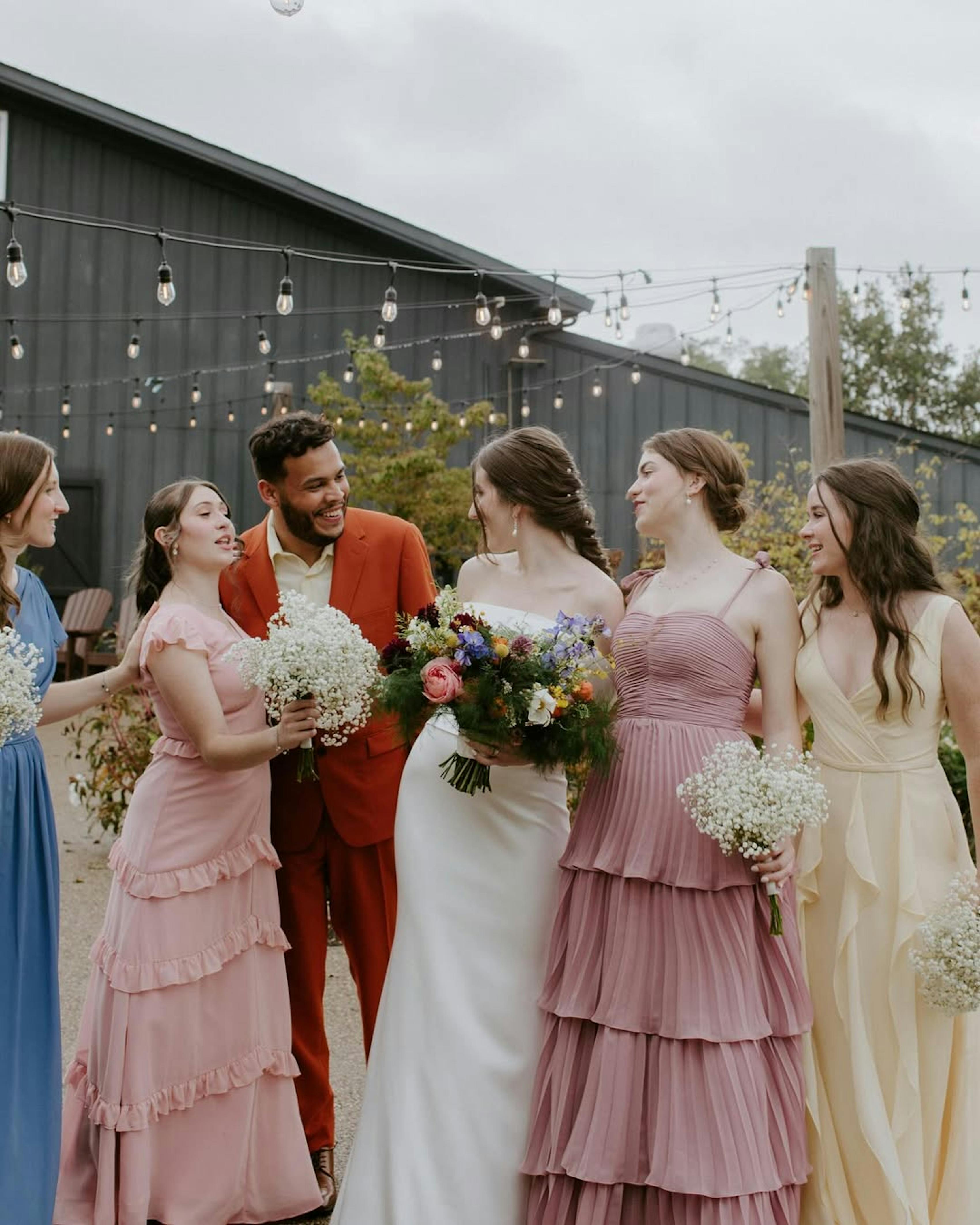 Colorful men's wedding suit for groomsman in terracotta color at floral barn wedding