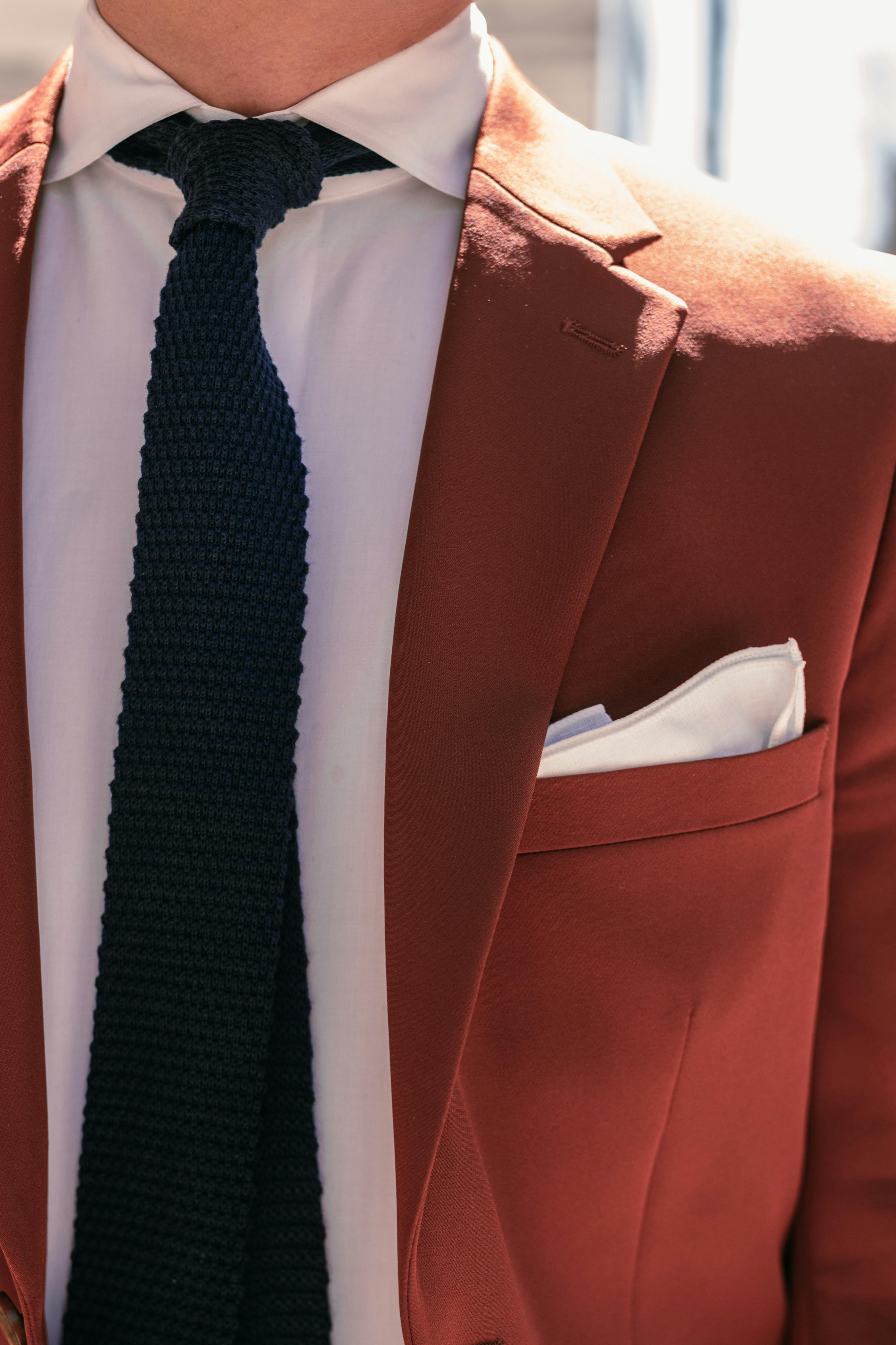 Clay color terracotta suit for men detail with black knit tie and white pocket square