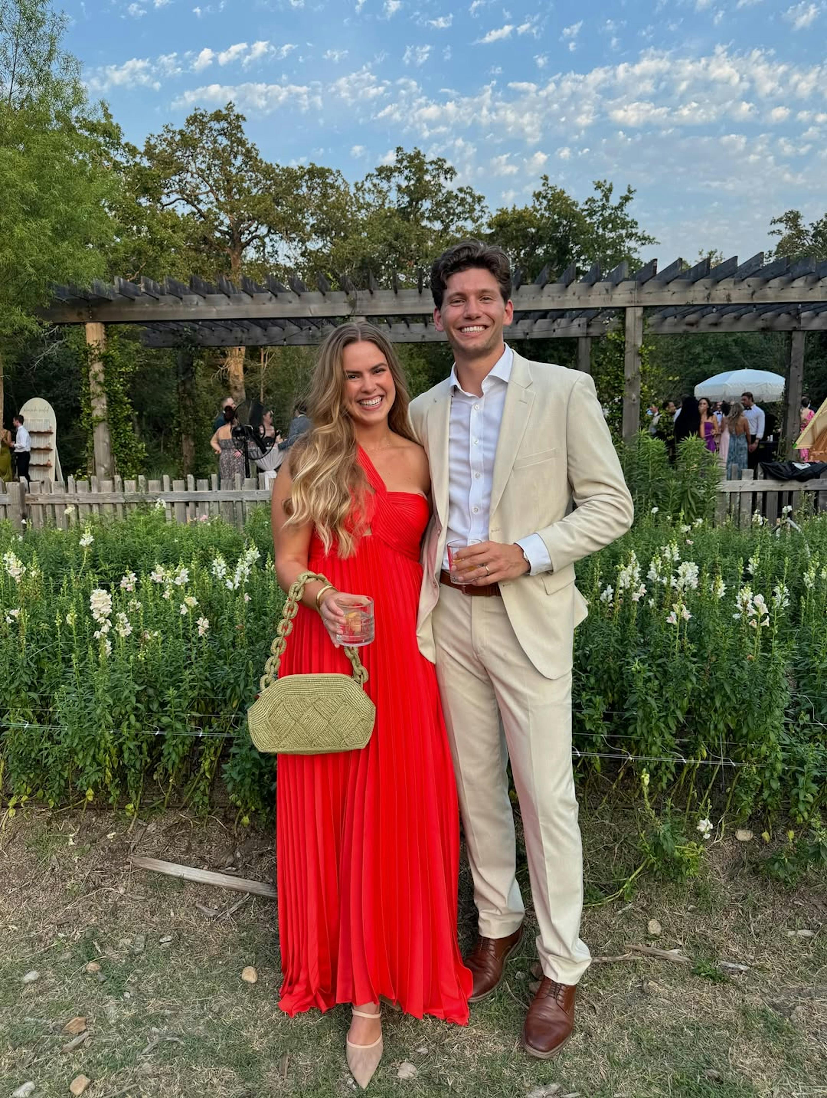 Summer cocktail outfits with red wedding guest dress and men's tan suit