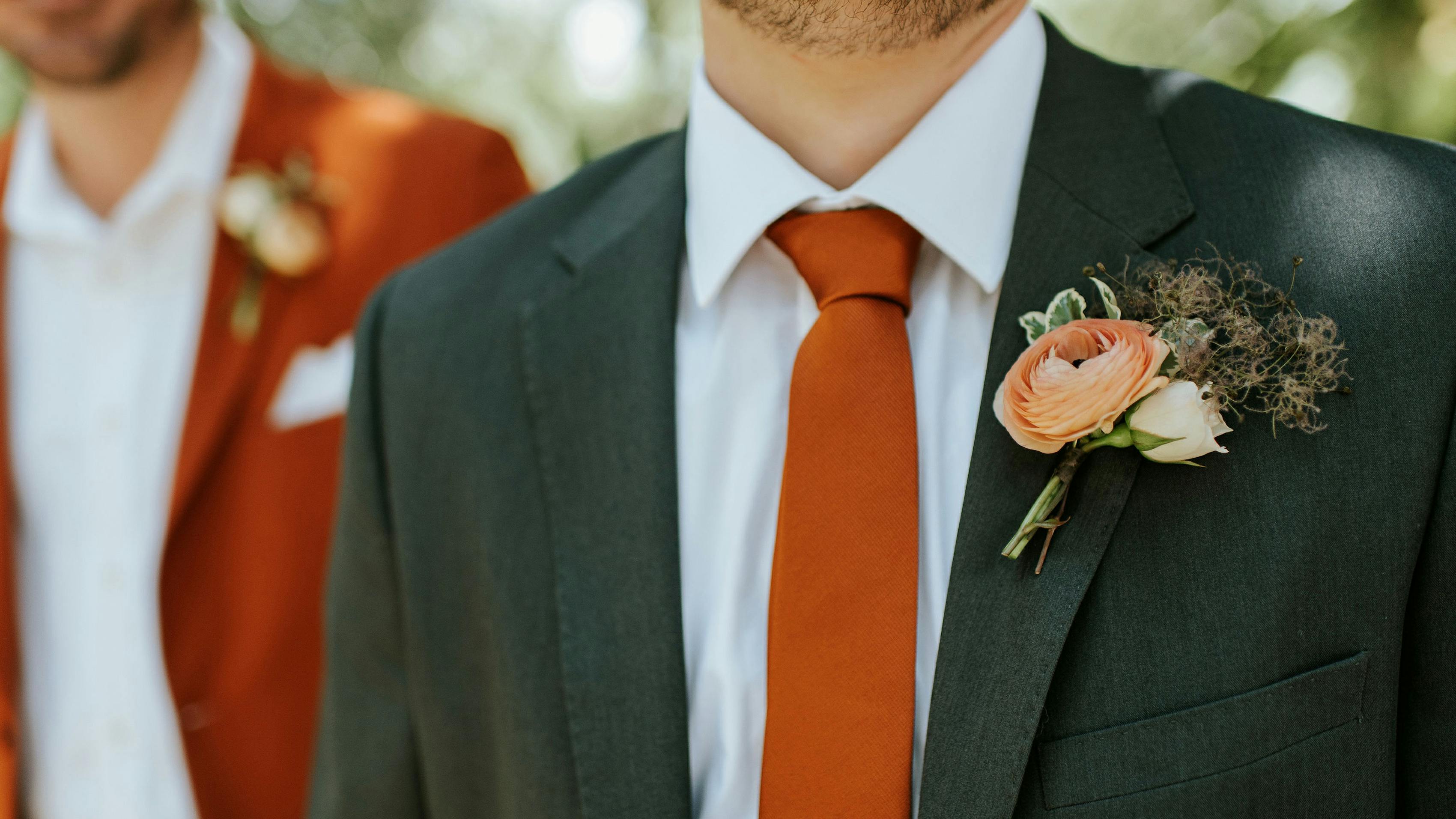 Details of men's green suit and burnt orange suit coordinating fall wedding colors