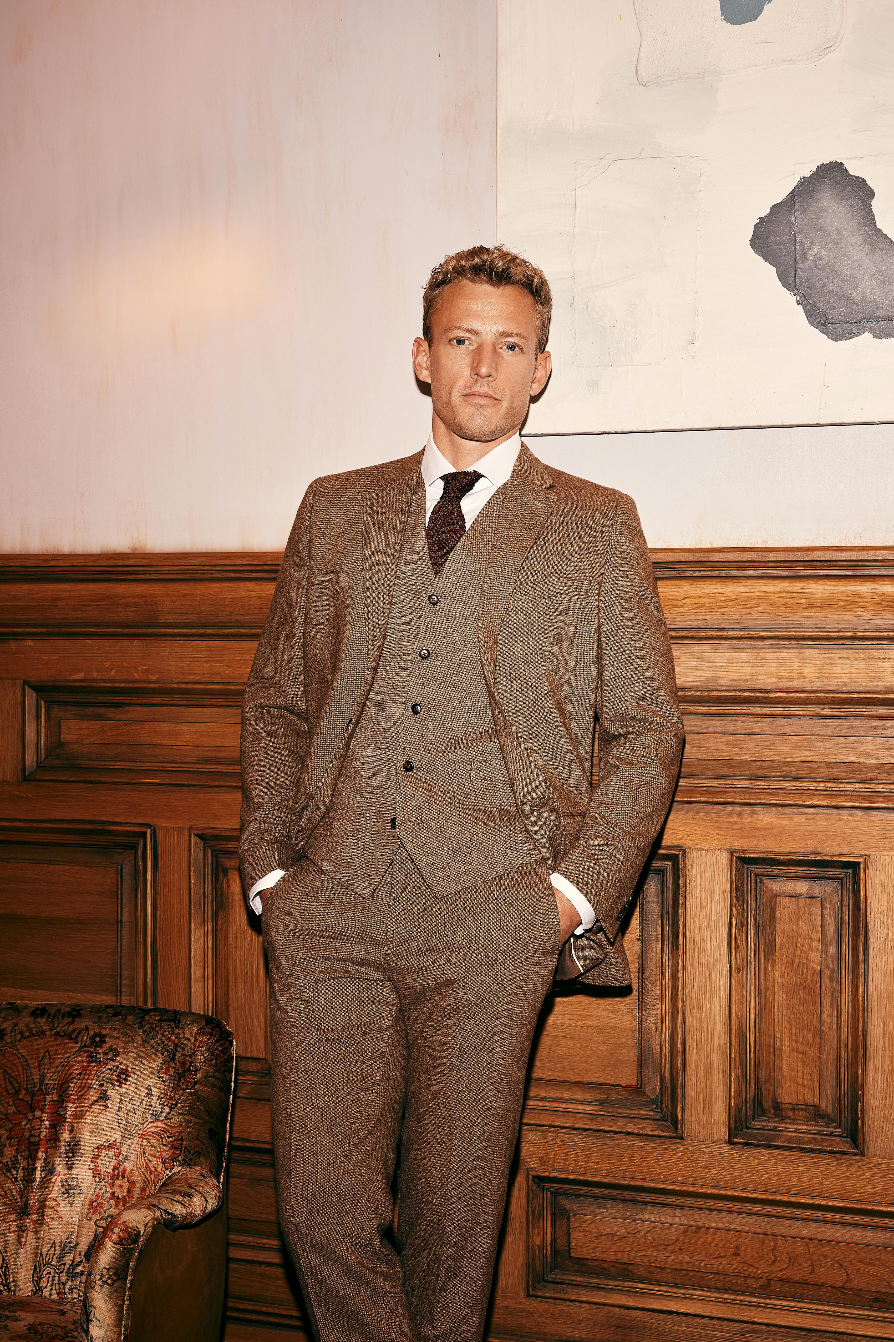Simple styling for three-piece men's brown tweed wedding suit in vintage venue