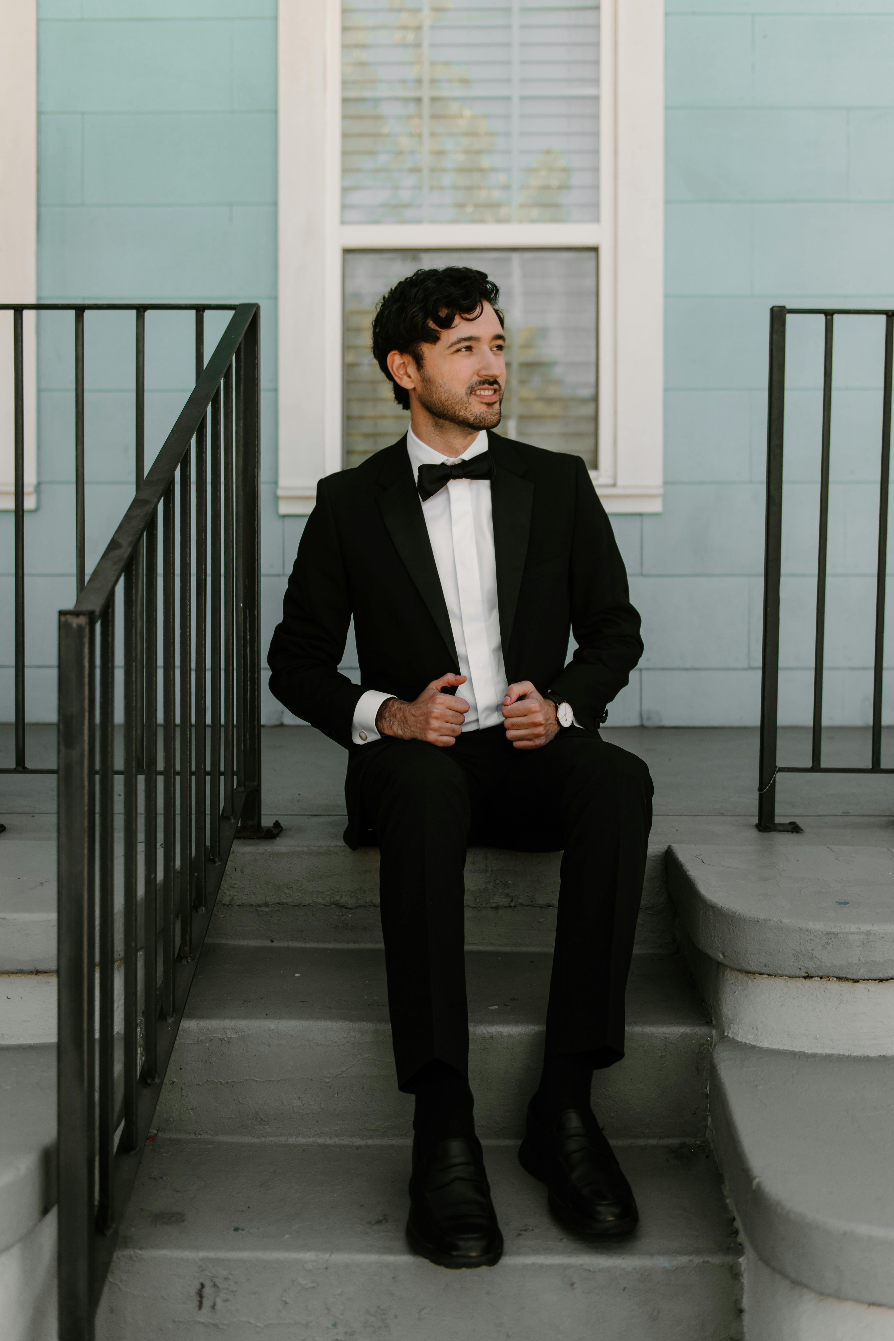 Wedding guest wearing men's black tuxedo with simple styling