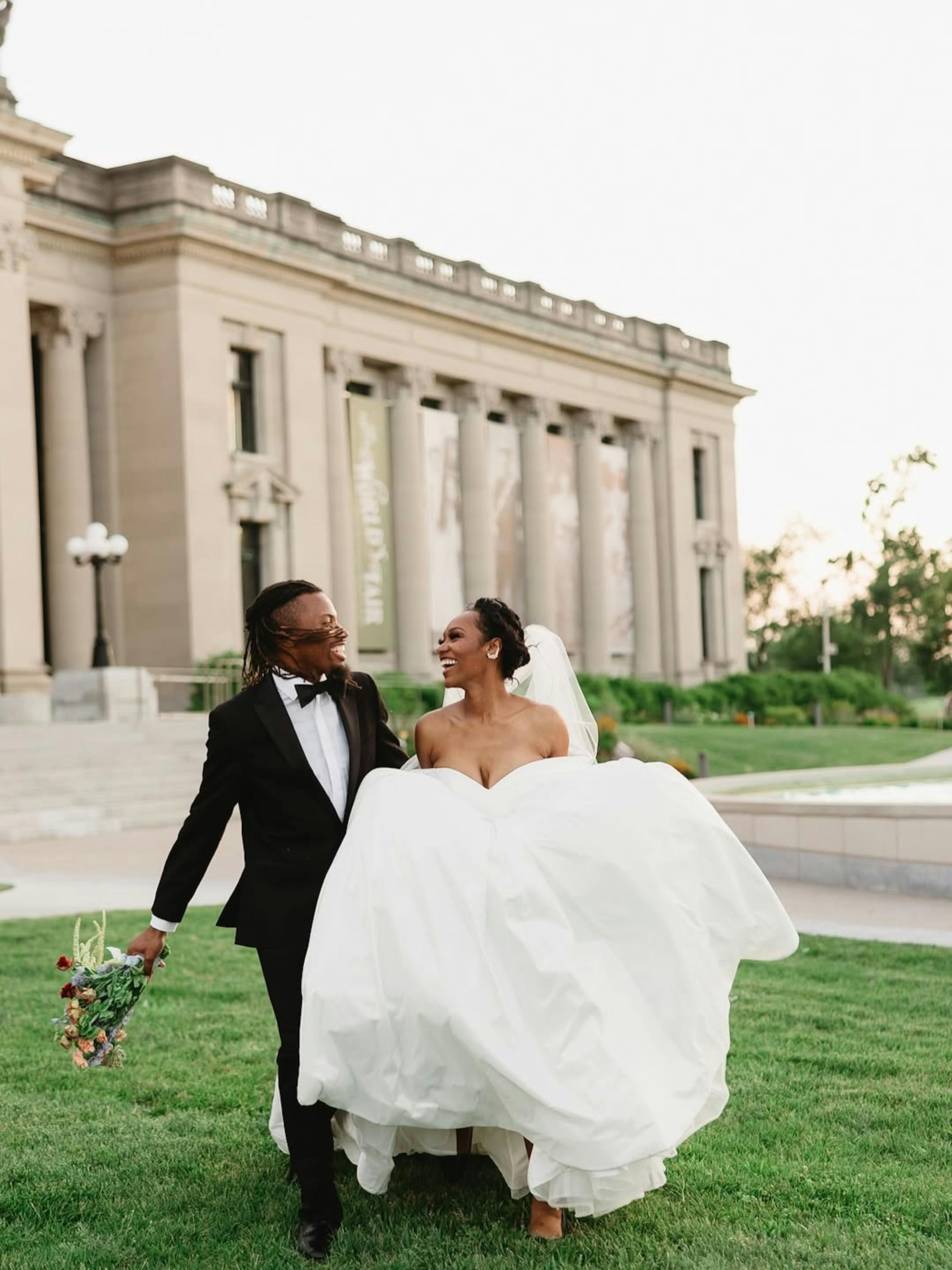Bride and groom at outdoor black tie wedding wearing black velvet tuxedo and gown