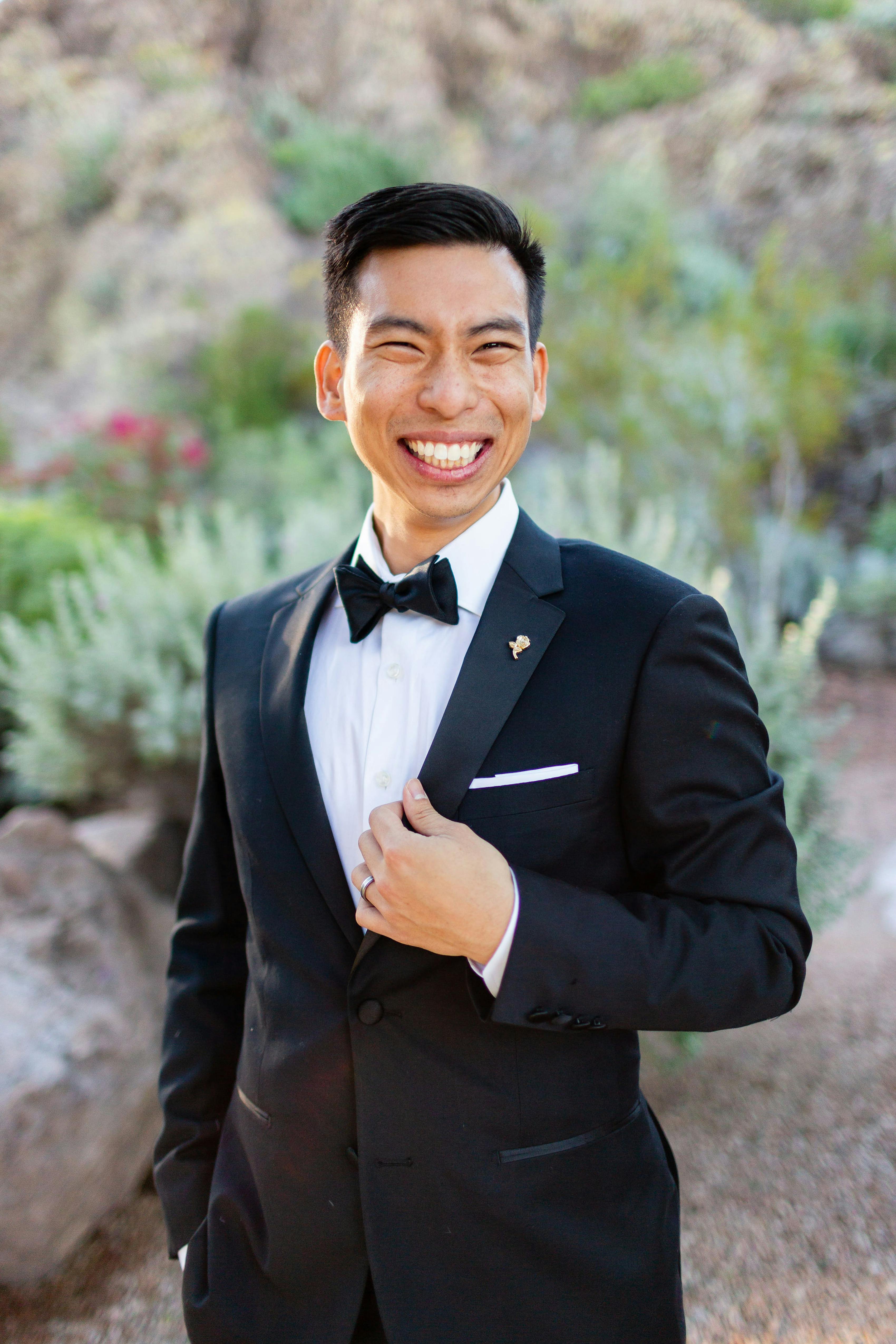 Man wearing subtle lapel pin on black tuxedo for wedding style
