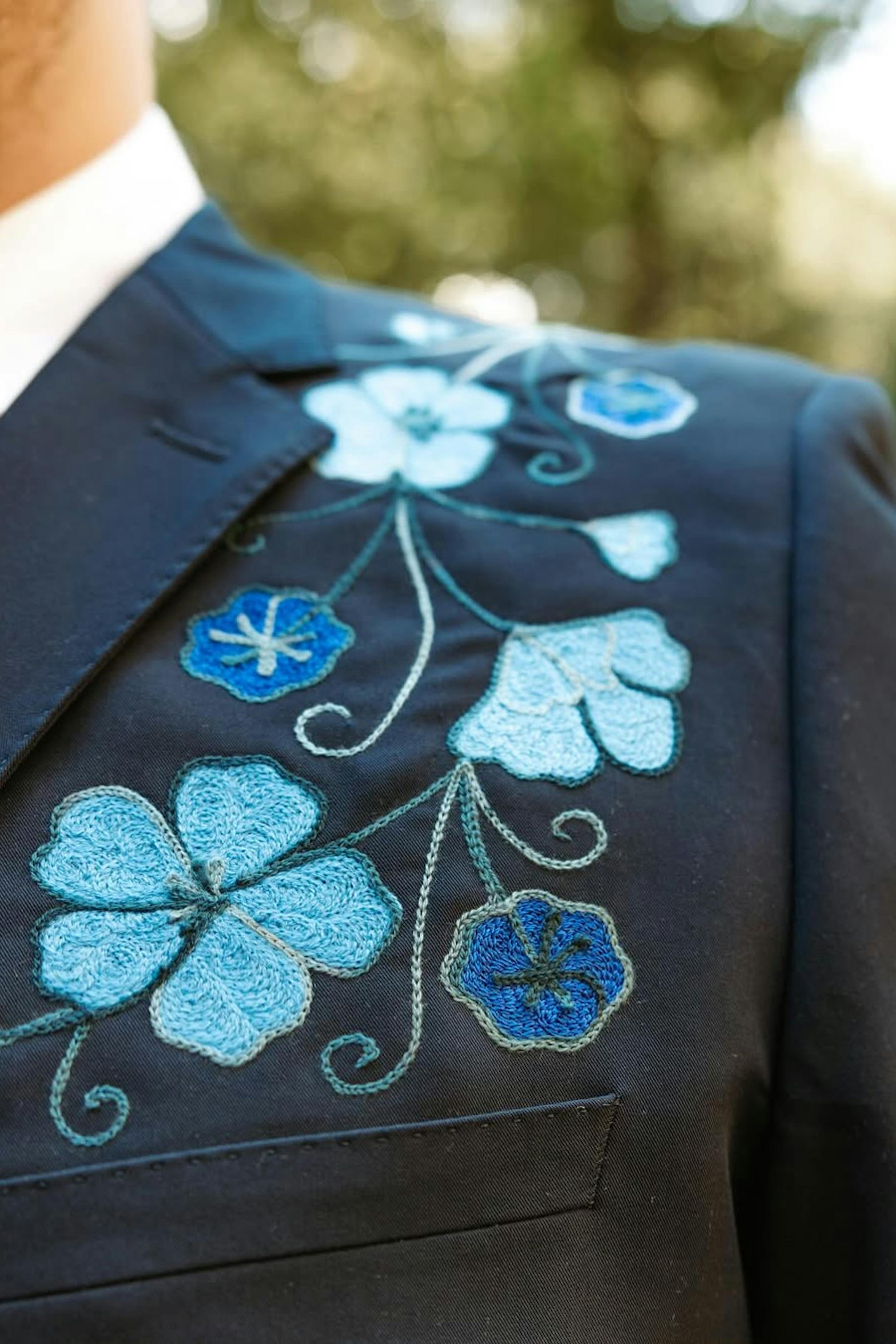 Custom floral embroidery on navy blue suit for unique men's formal style