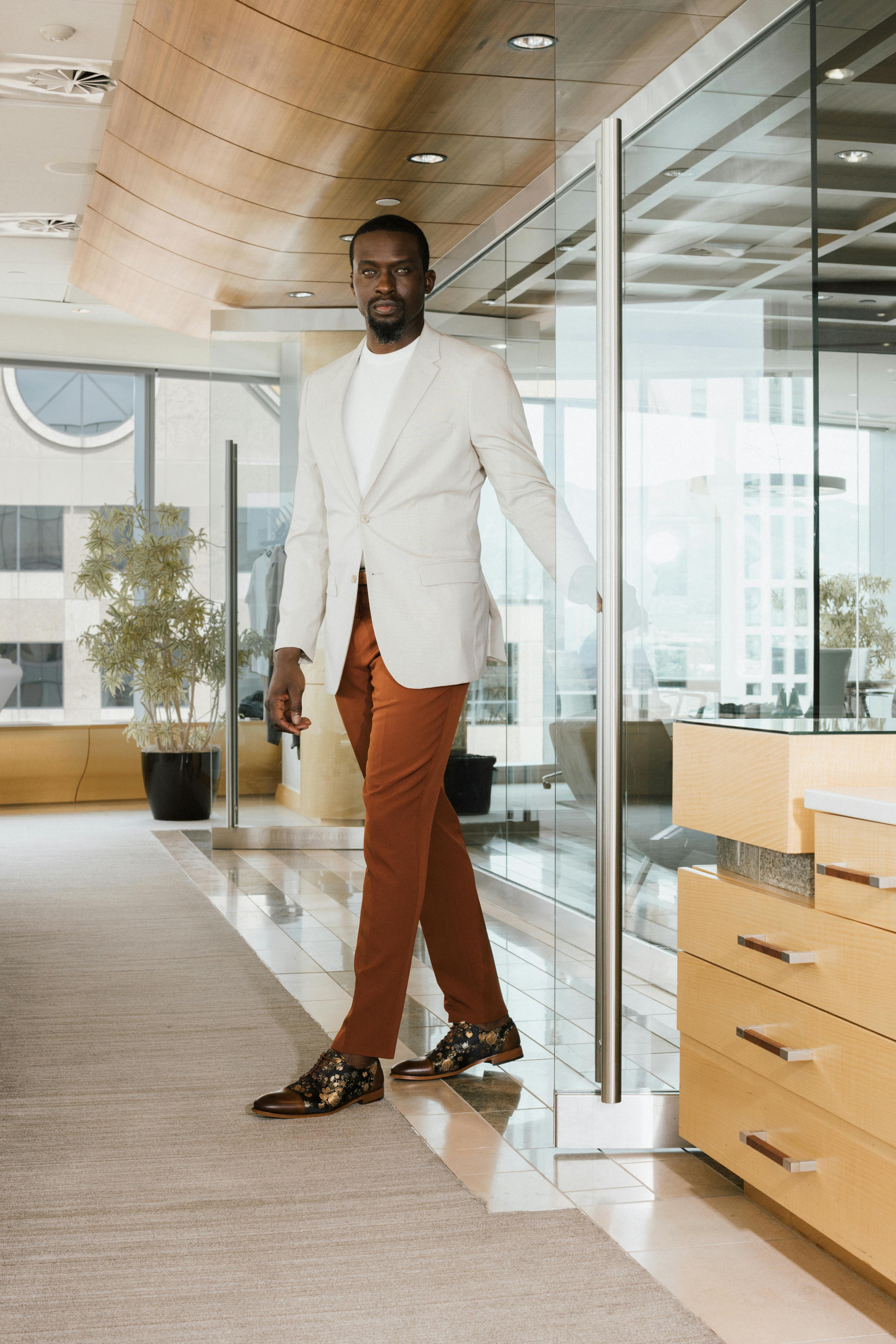 Man wearing mix and match suit set with light tan blazer and clay suit pants