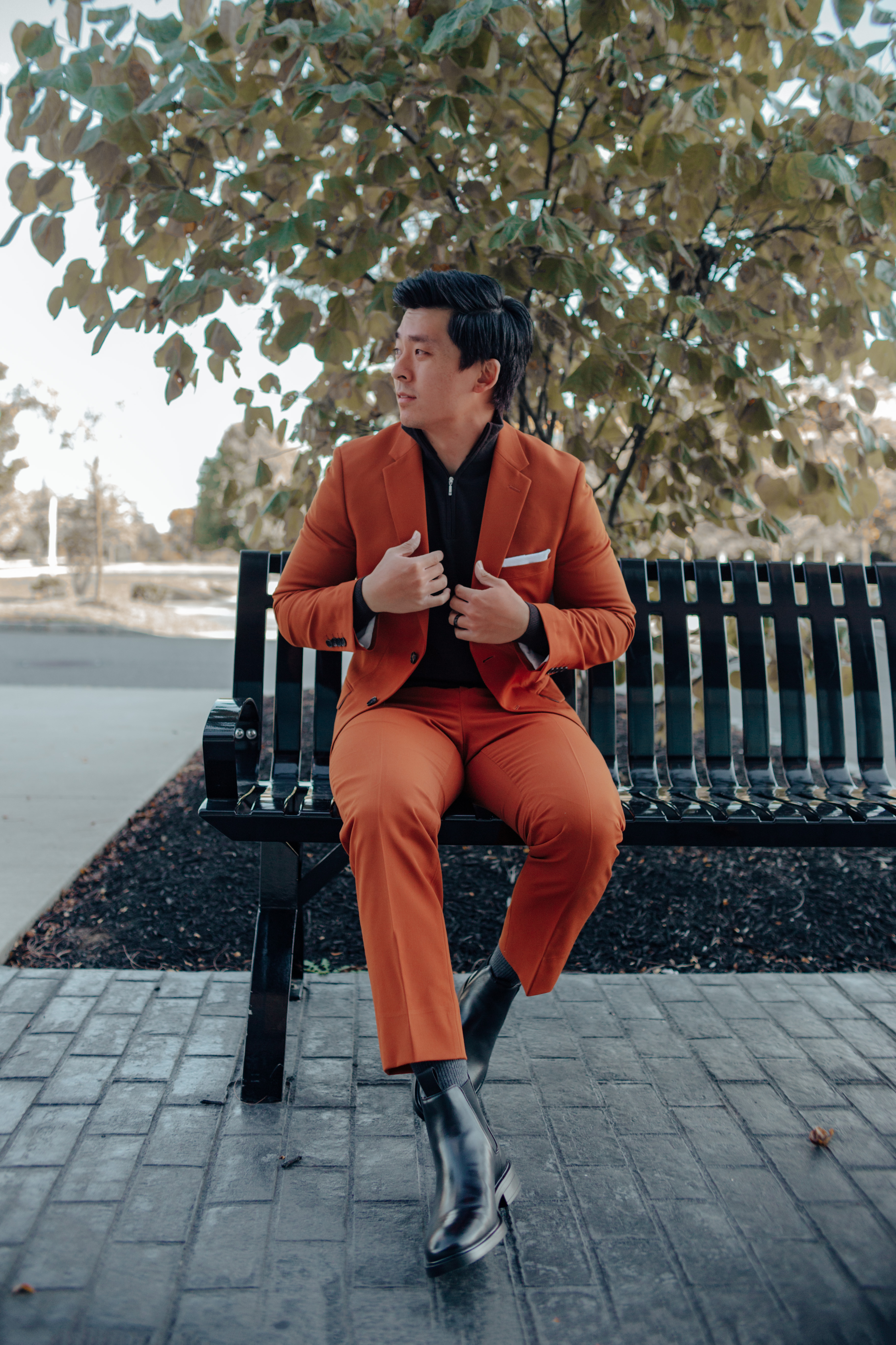 Man wearing unique outfit with orange suit and black sweater