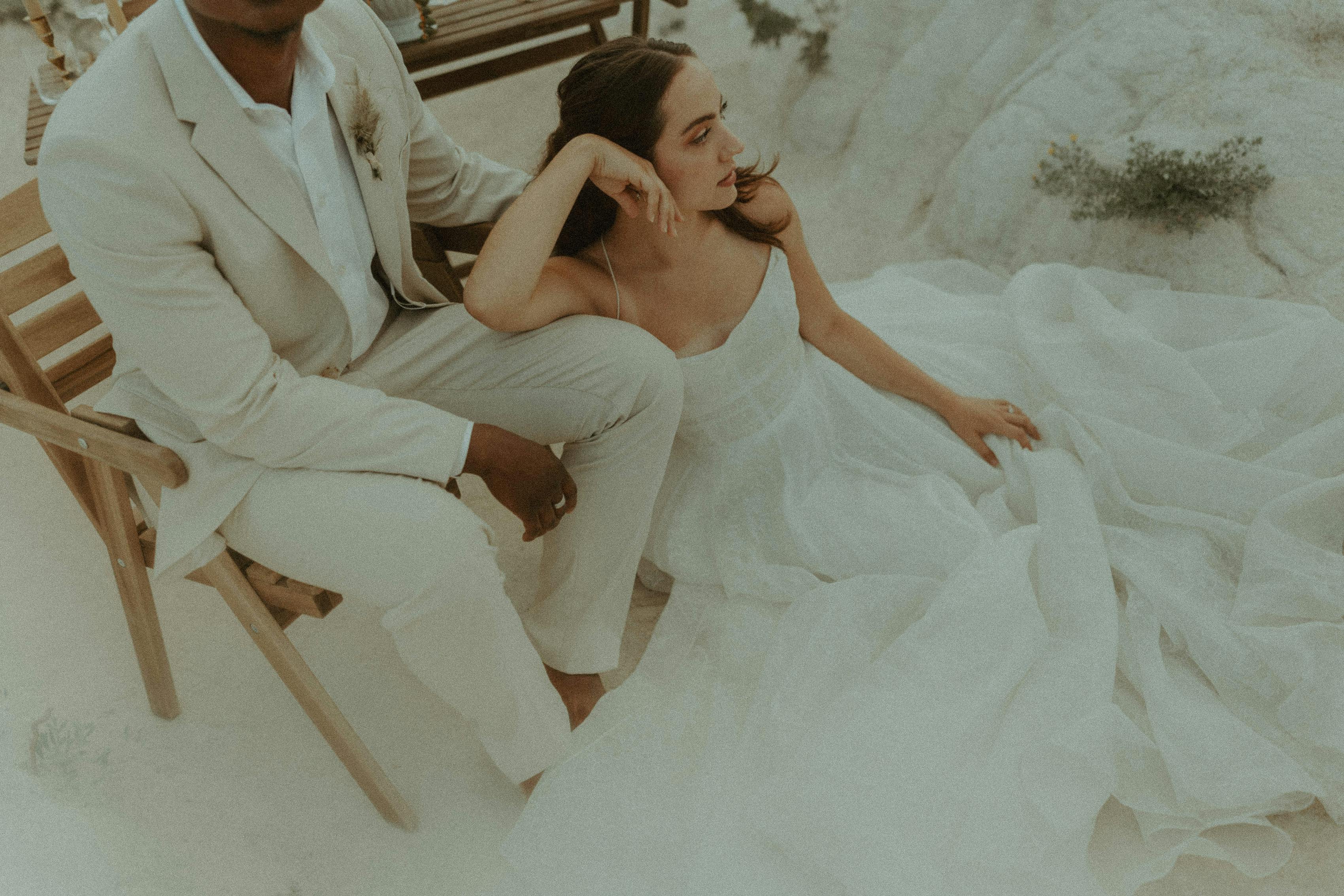 Groom wearing light linen suit with bride wearing tulle wedding gown