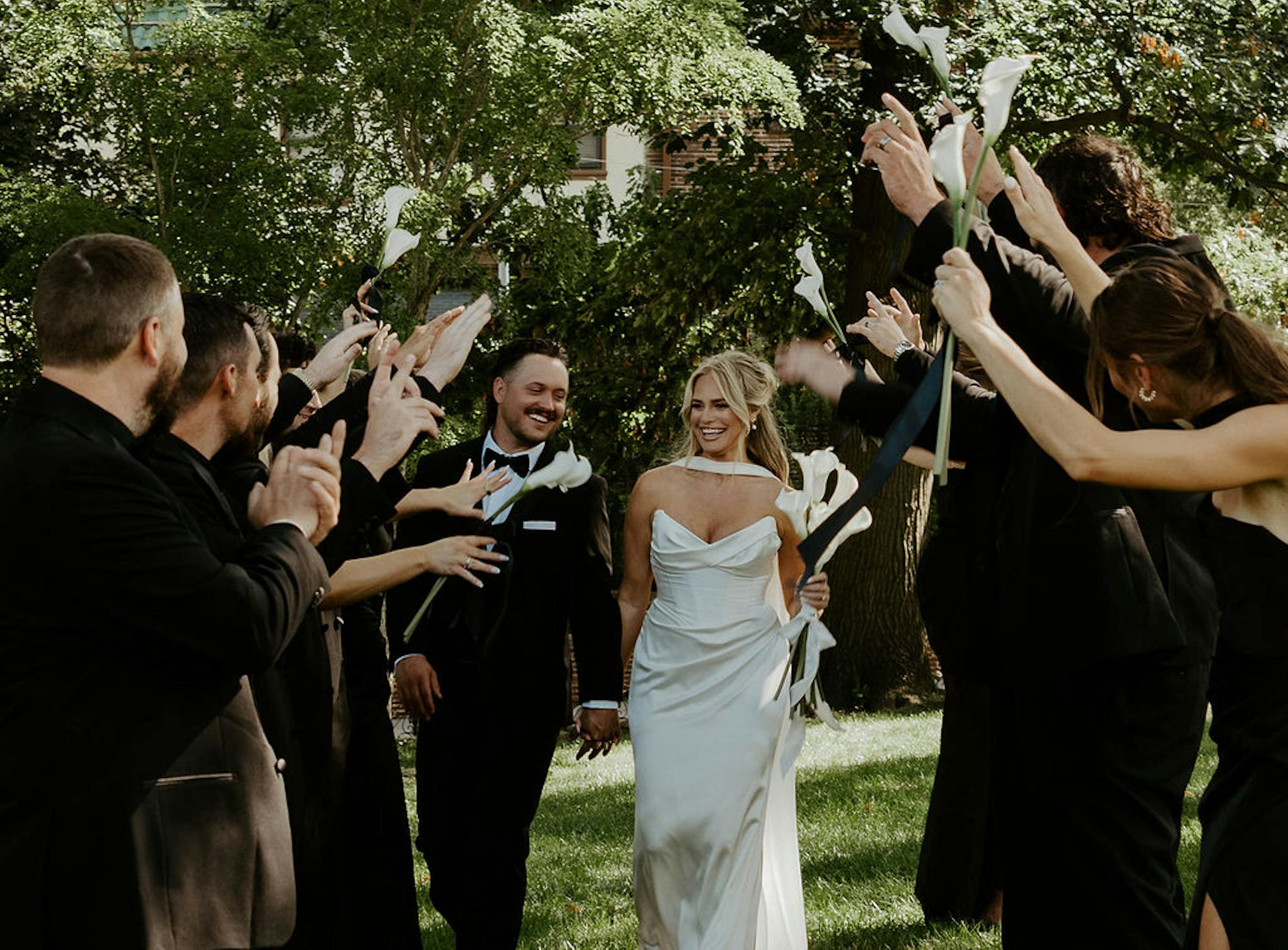 all black bridal party looks with white calla lilies and corset wedding gown
