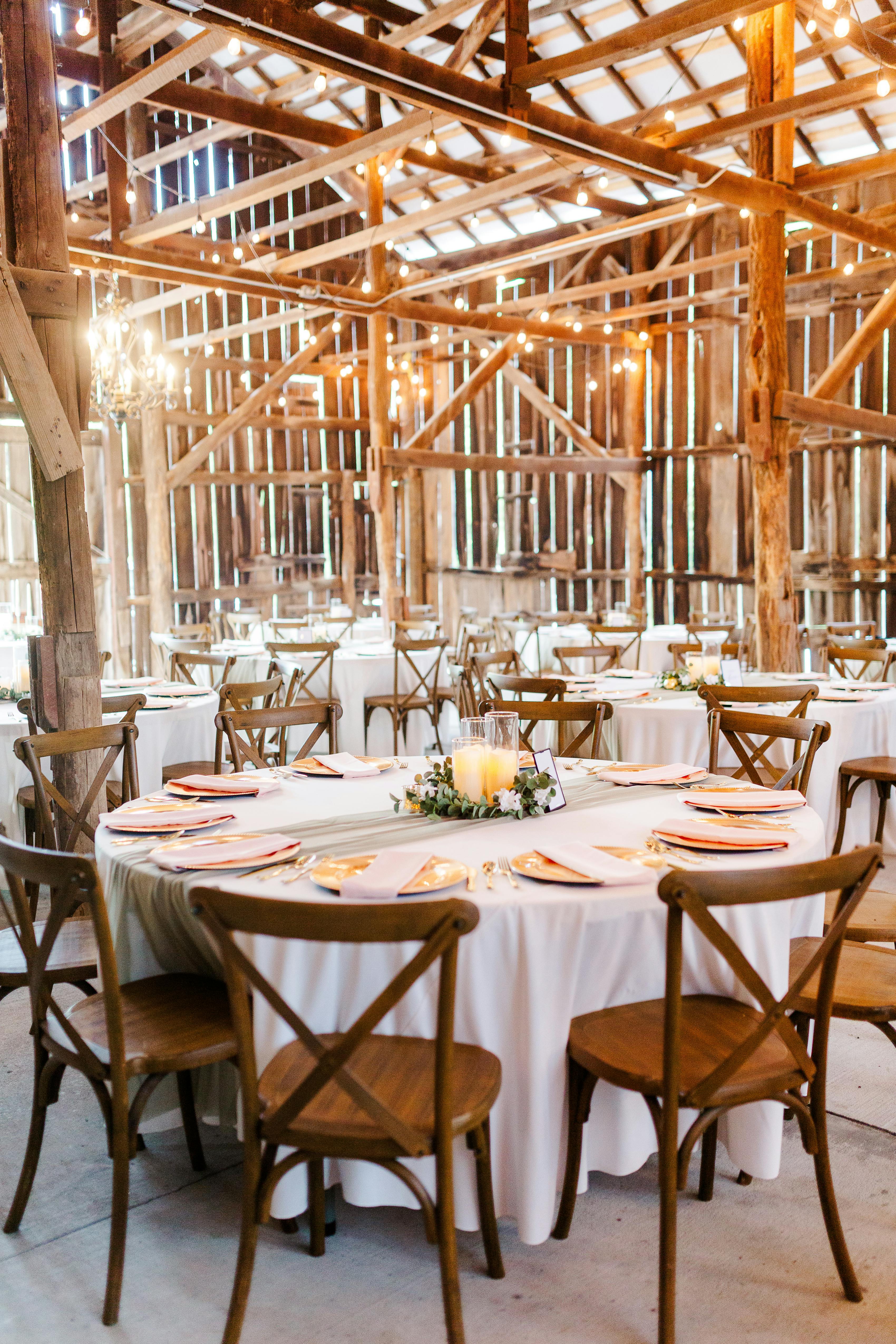 Modern rustic farmhouse wedding venue setup with simple tablescape and wood decor