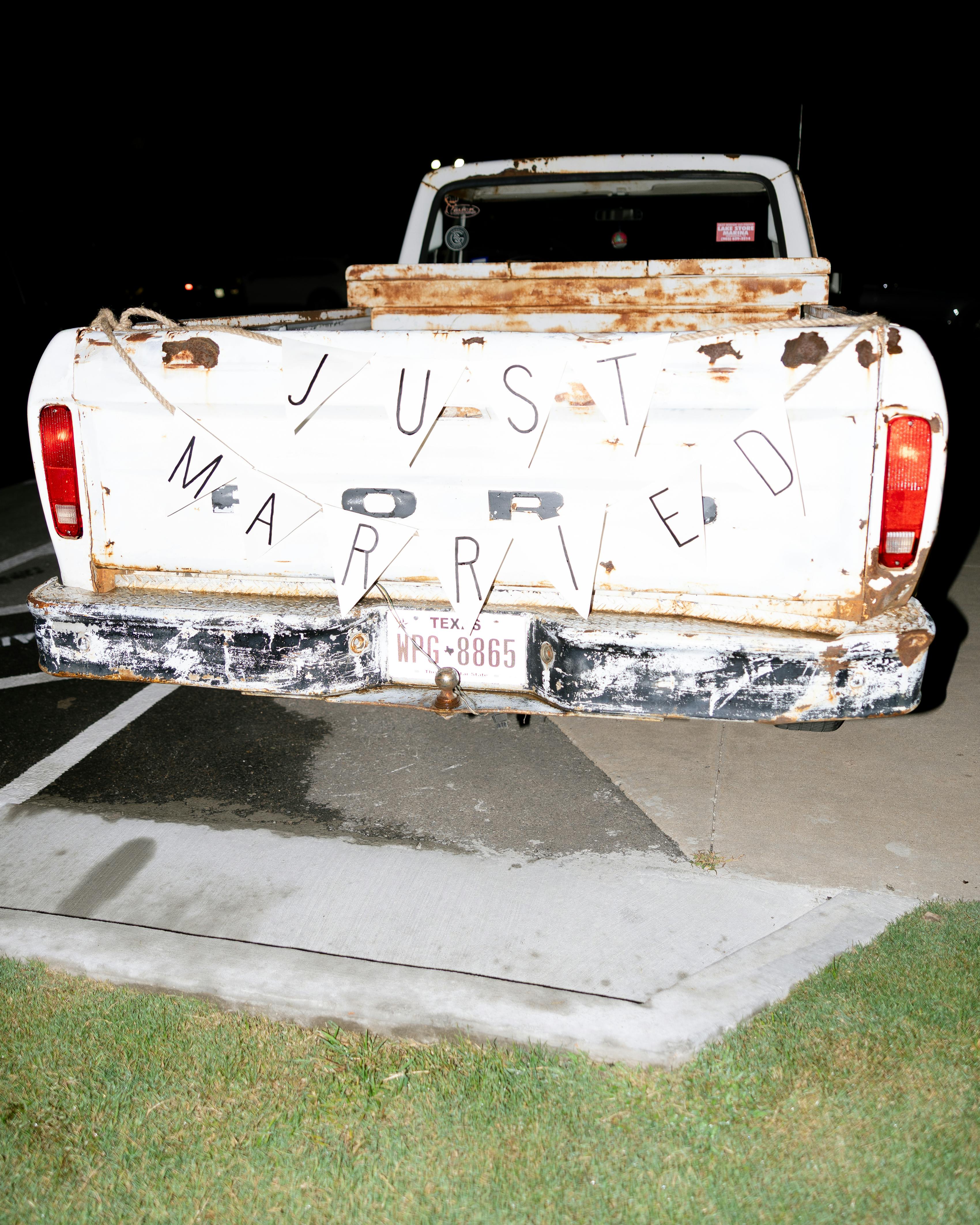 White vintage Ford truck with "Just Married" sign for wedding exit