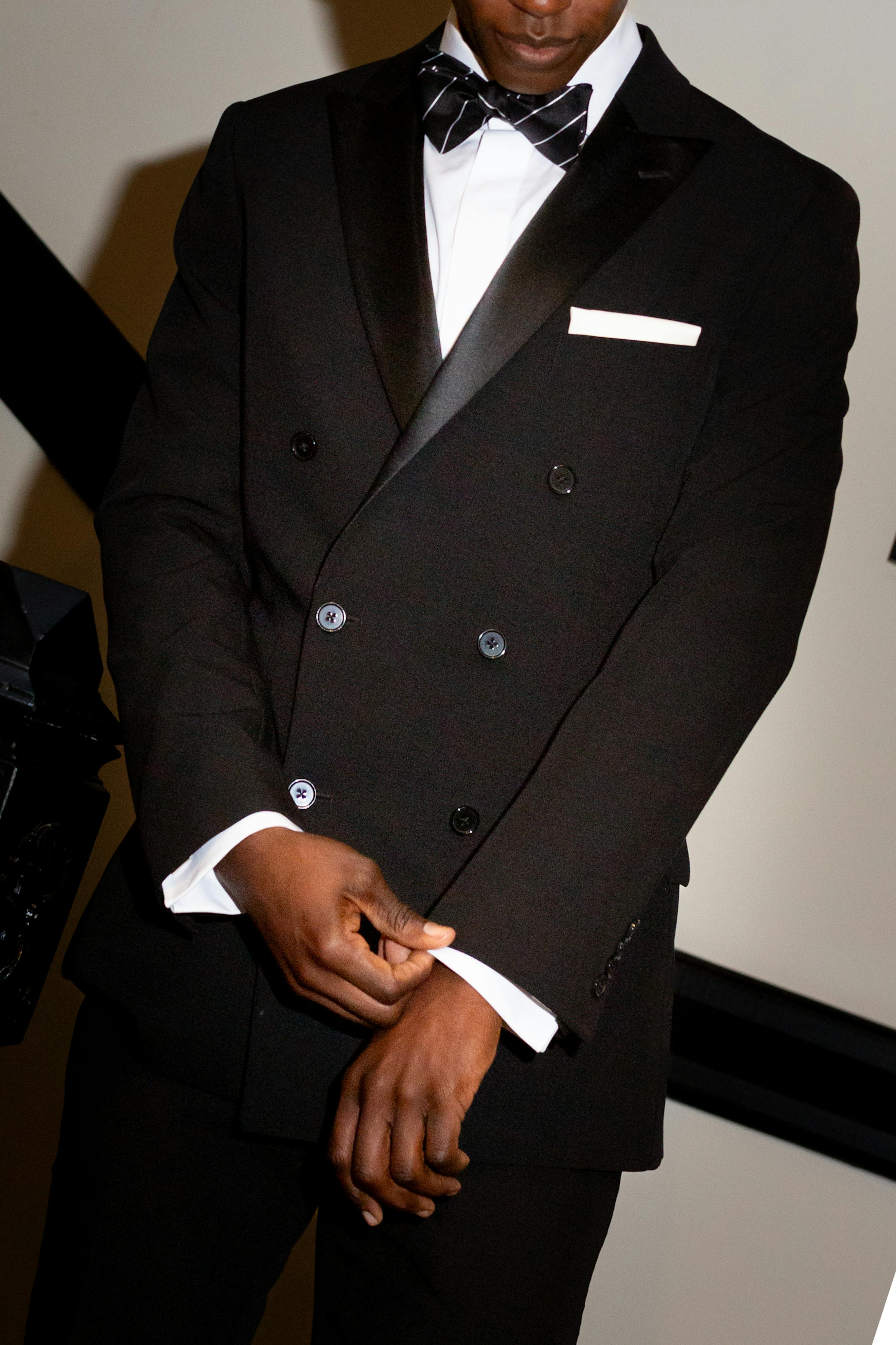 Men wearing black double breasted tuxedo with shiny satin lapel in stairwell