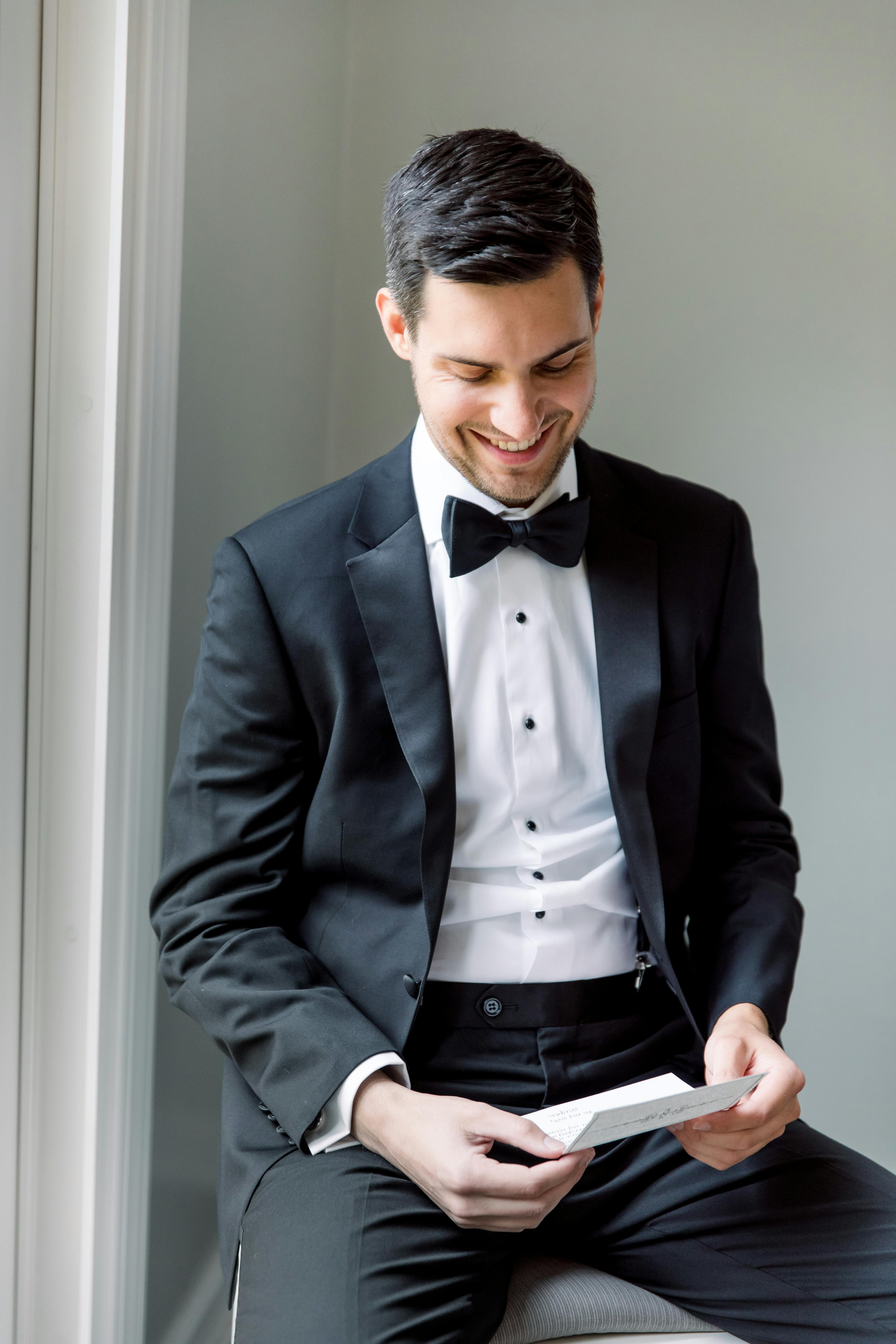 Man in black tuxedo holding letter for formal apology costume